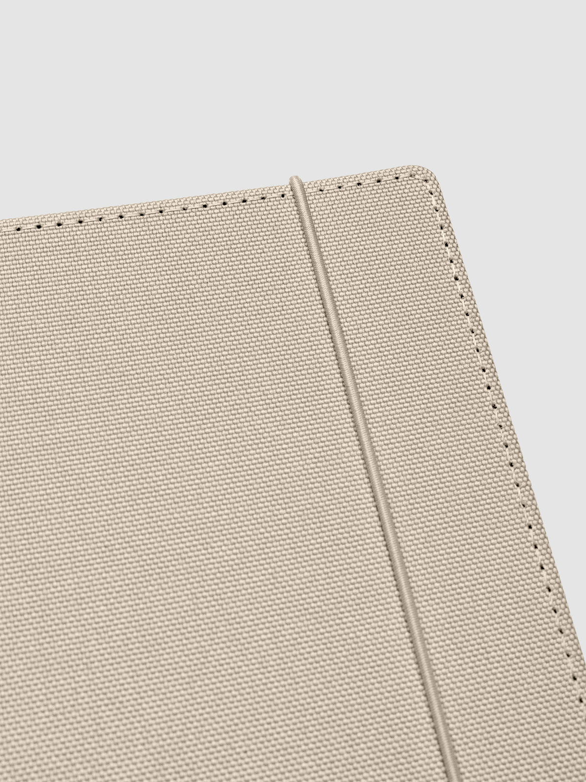Close up of the beige bungee closure on the Archive Bookcloth Planner Cover.