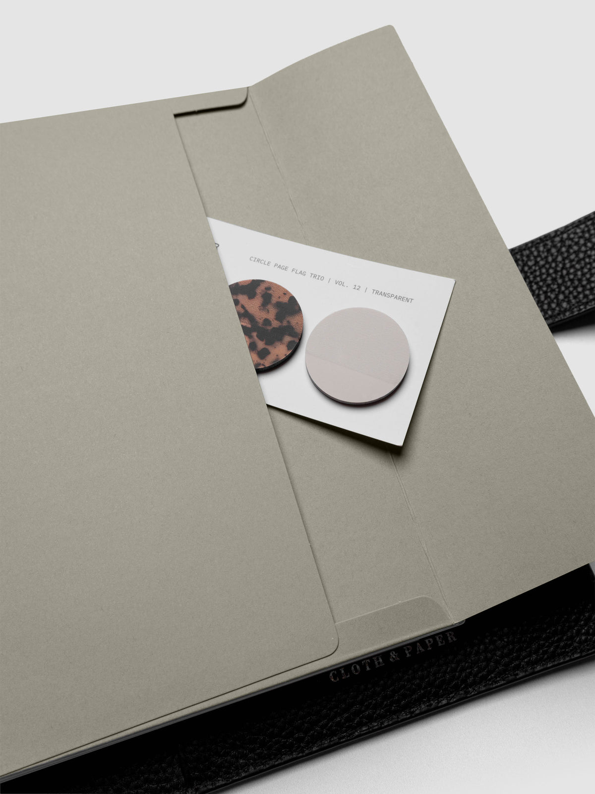 Beige Envelope Storage Holder shown inside a black, leather A5 agenda with page flags inside.
