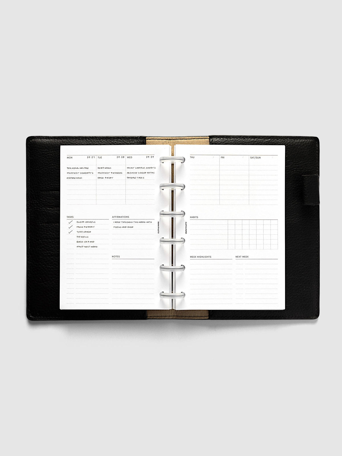 Weekly Essentials Planner Inserts, CP Petite 6-Disc Punch, weekly spread open on frosted discs in a black leather planner