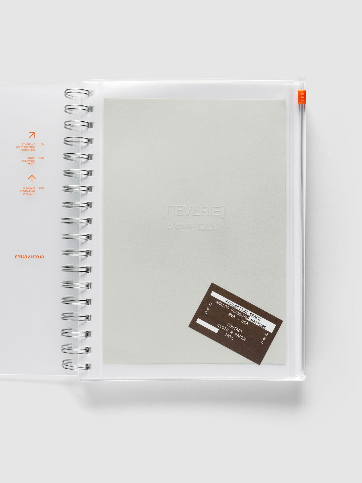 Reverie Storage Holder bound into a spiral notebook in size HP Classic Spiral, with the light grey embossed dashboard and brown sticker inside the clear pouch.