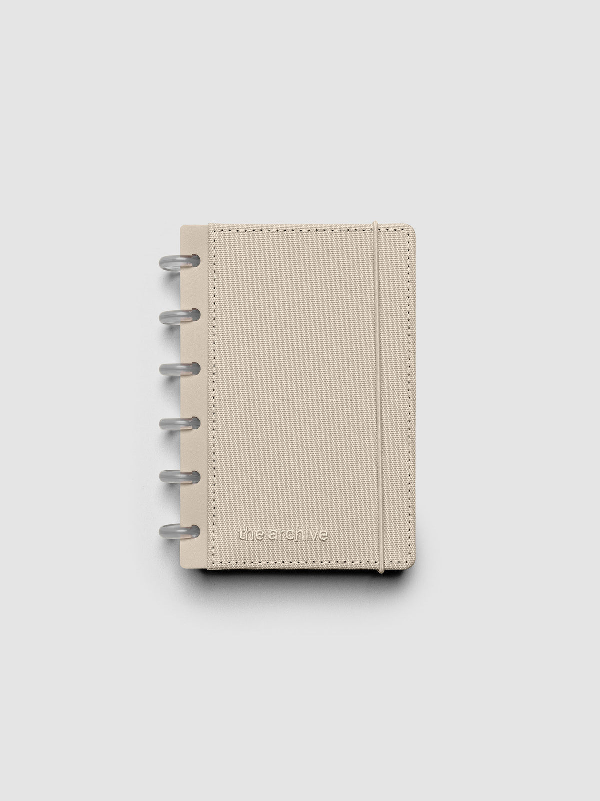 CP Petite discbound planner with a beige bookcloth cover against a grey background.