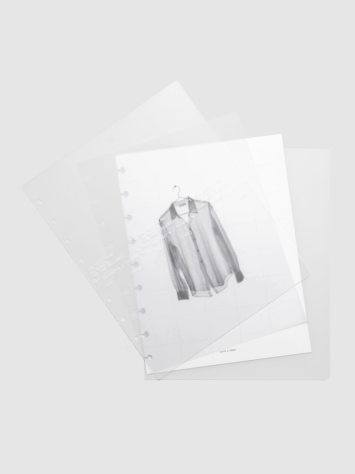 Transparent planner cover set with white printed text design and accompanying black and white dashboard with an image of a tailored shirt on a hanger shown offset. Pre-punched for discbound planners shown in size HP Classic.
