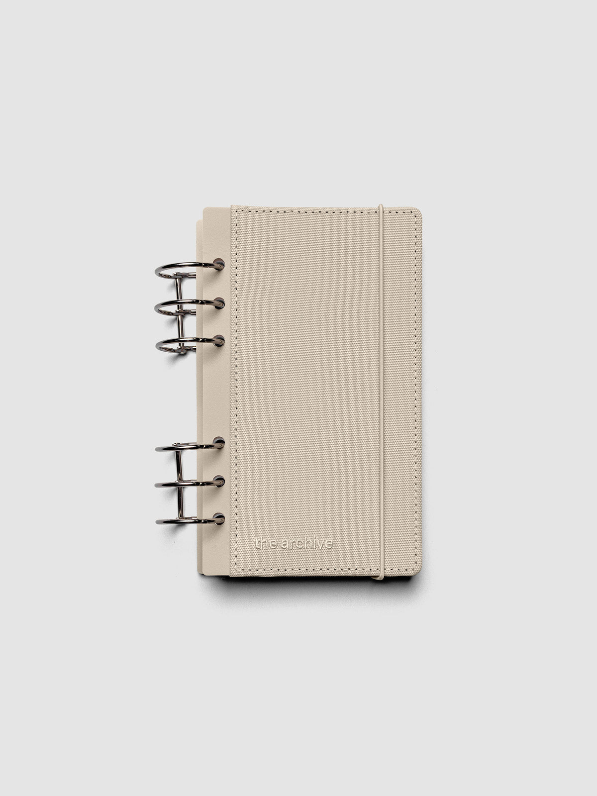 Personal ring bound planner with a beige bookcloth cover against a grey background.
