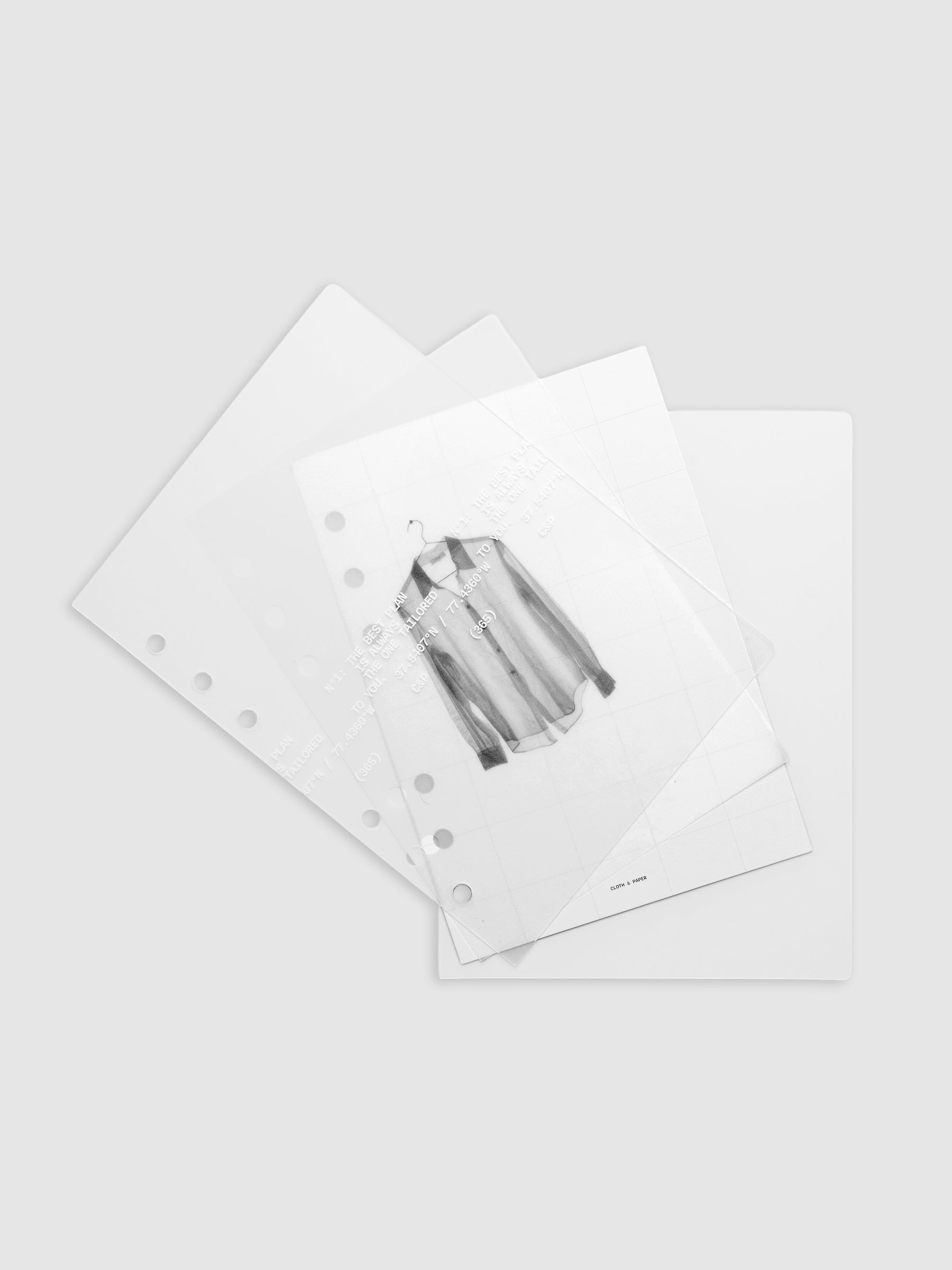 Transparent planner cover set with white printed text design and accompanying black and white dashboard with an image of a tailored shirt on a hanger shown offset. Pre-punched for 6-ring planners shown in size Personal Wide.
