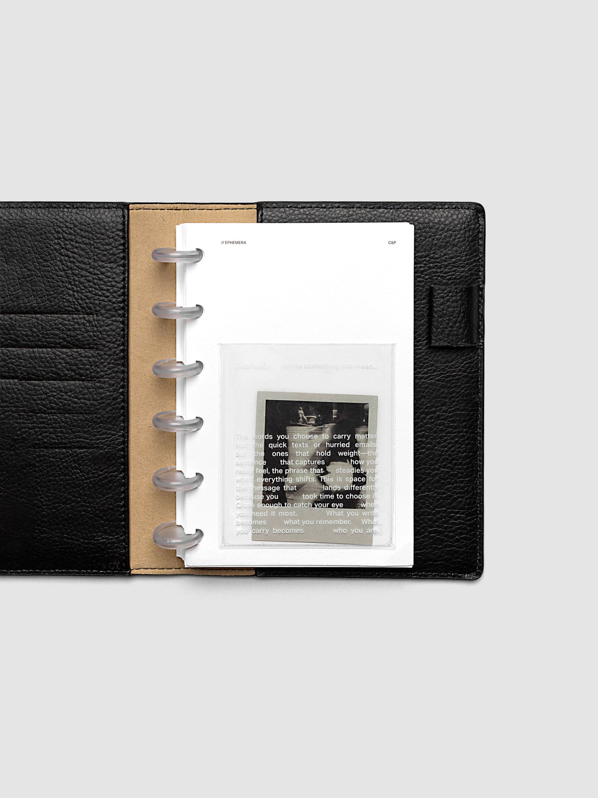 White Ephemera Planner Dashboard shown in size CP Petite in a black leather folio.