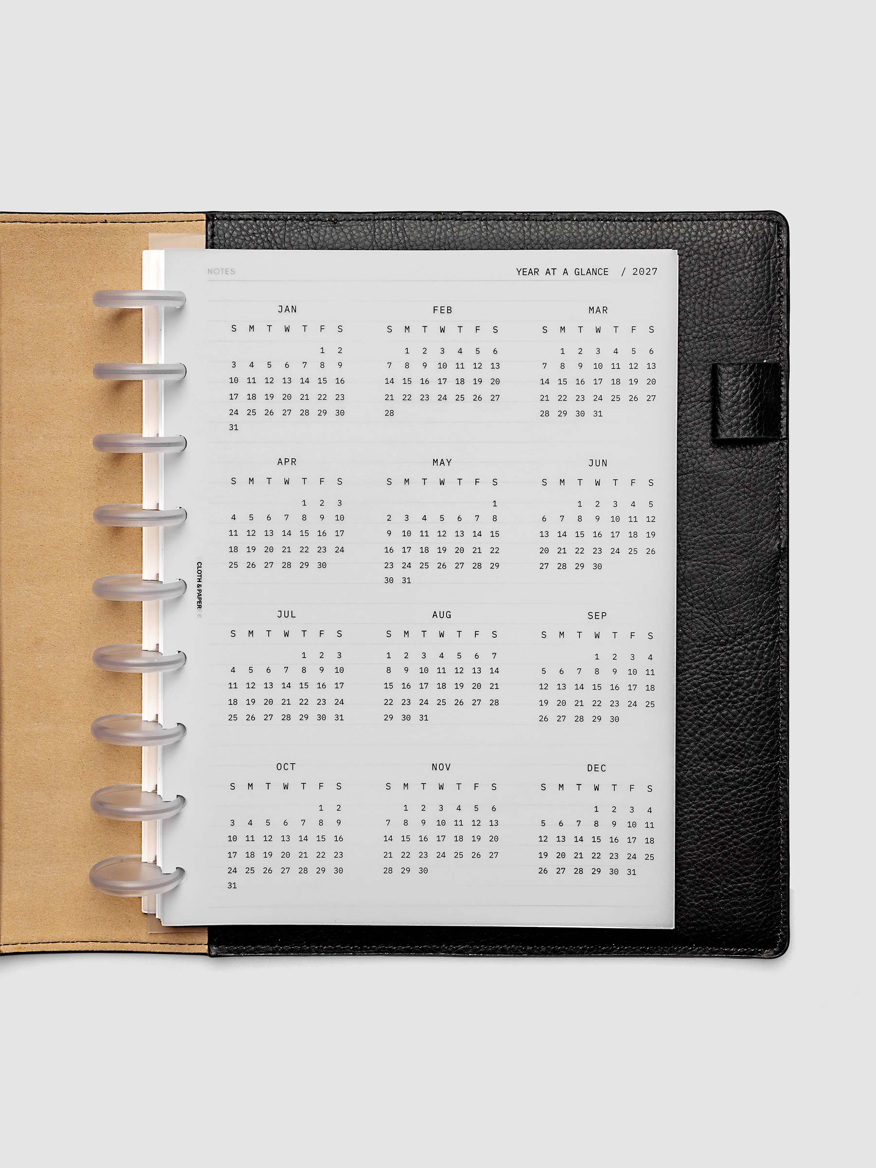 2027 Year At A Glance Dashboard Sunday Start, HP Classic 9-Disc Punch, translucent vellum year-at-a-glance calendar shown inside a planner