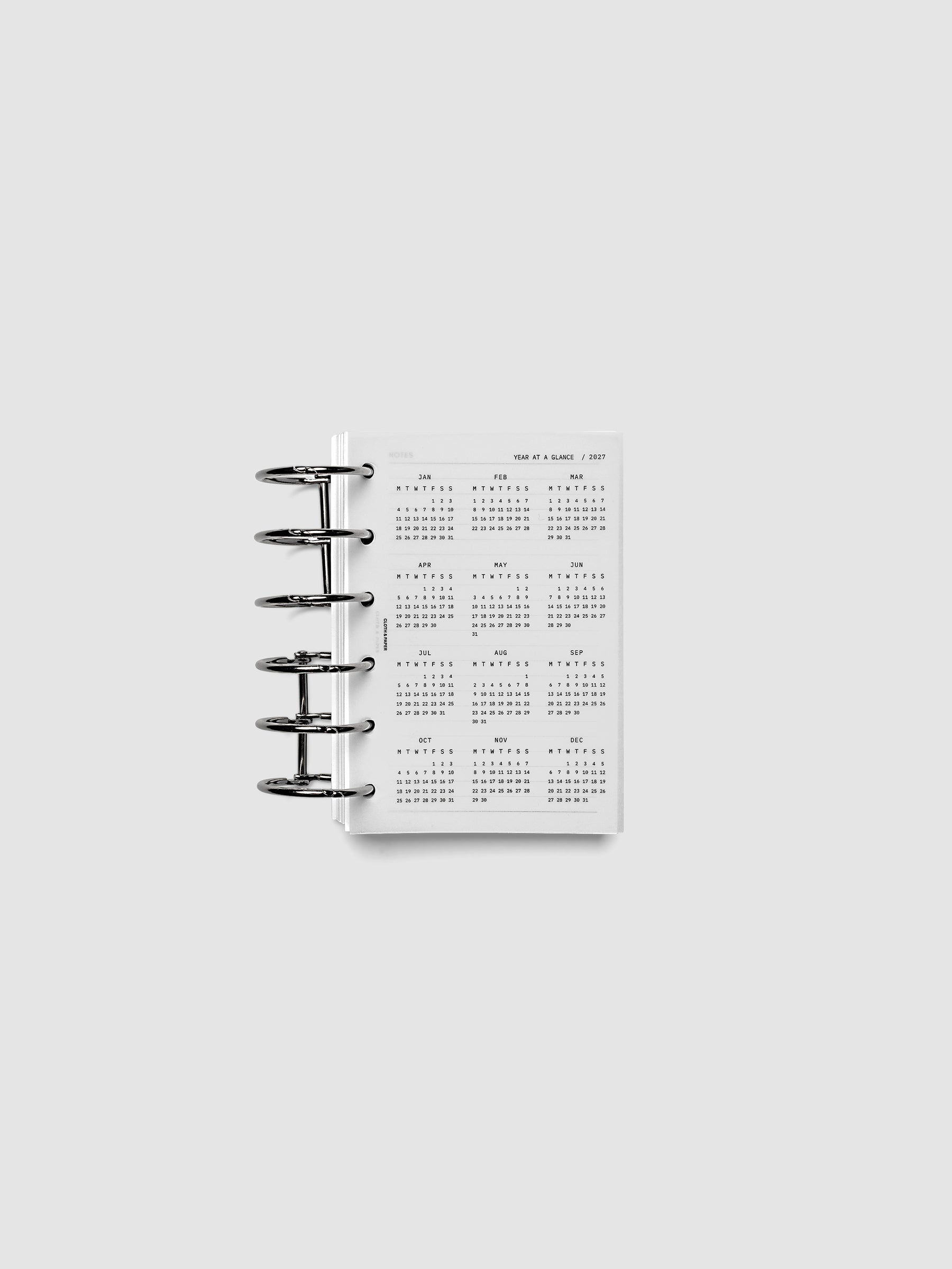 2027 Year At A Glance Dashboard Monday Start, Pocket 6-Ring Punch, translucent vellum year-at-a-glance calendar shown inside a planner