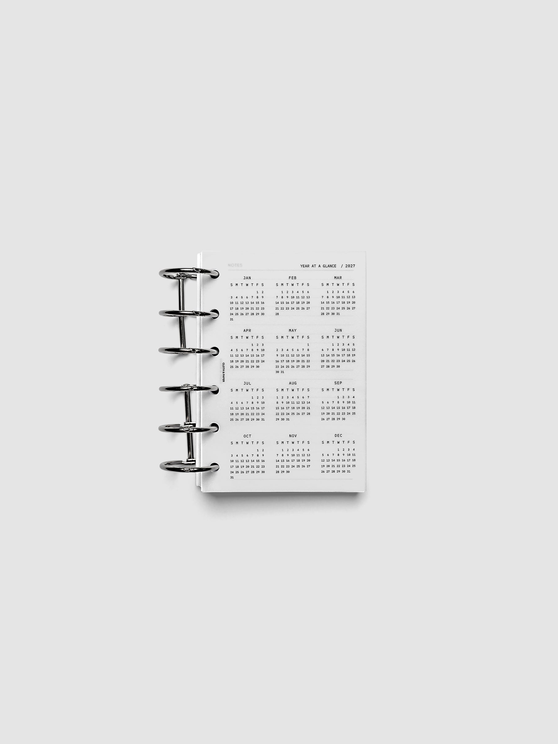 2027 Year At A Glance Dashboard Sunday Start, Pocket 6-Ring Punch, translucent vellum year-at-a-glance calendar shown inside a planner