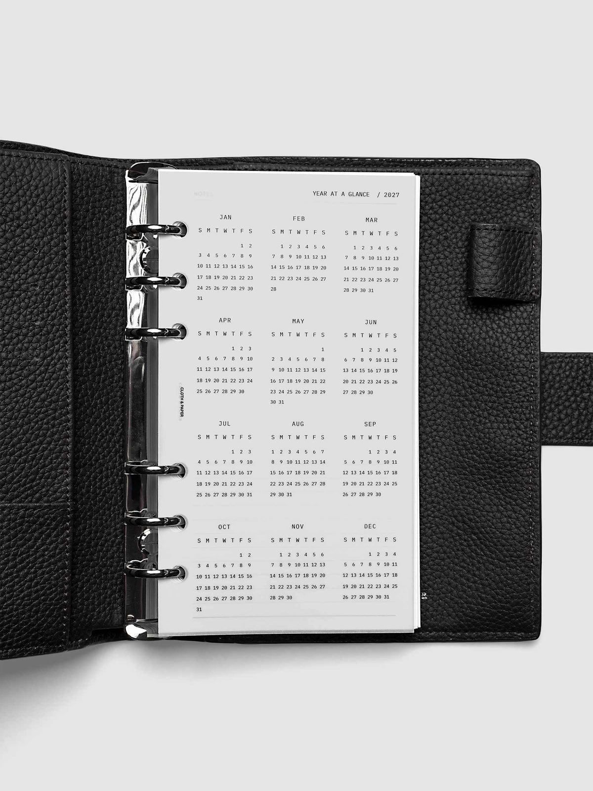 2027 Year At A Glance Dashboard Sunday Start, Personal 6-Ring Punch, translucent vellum year-at-a-glance calendar shown inside a planner