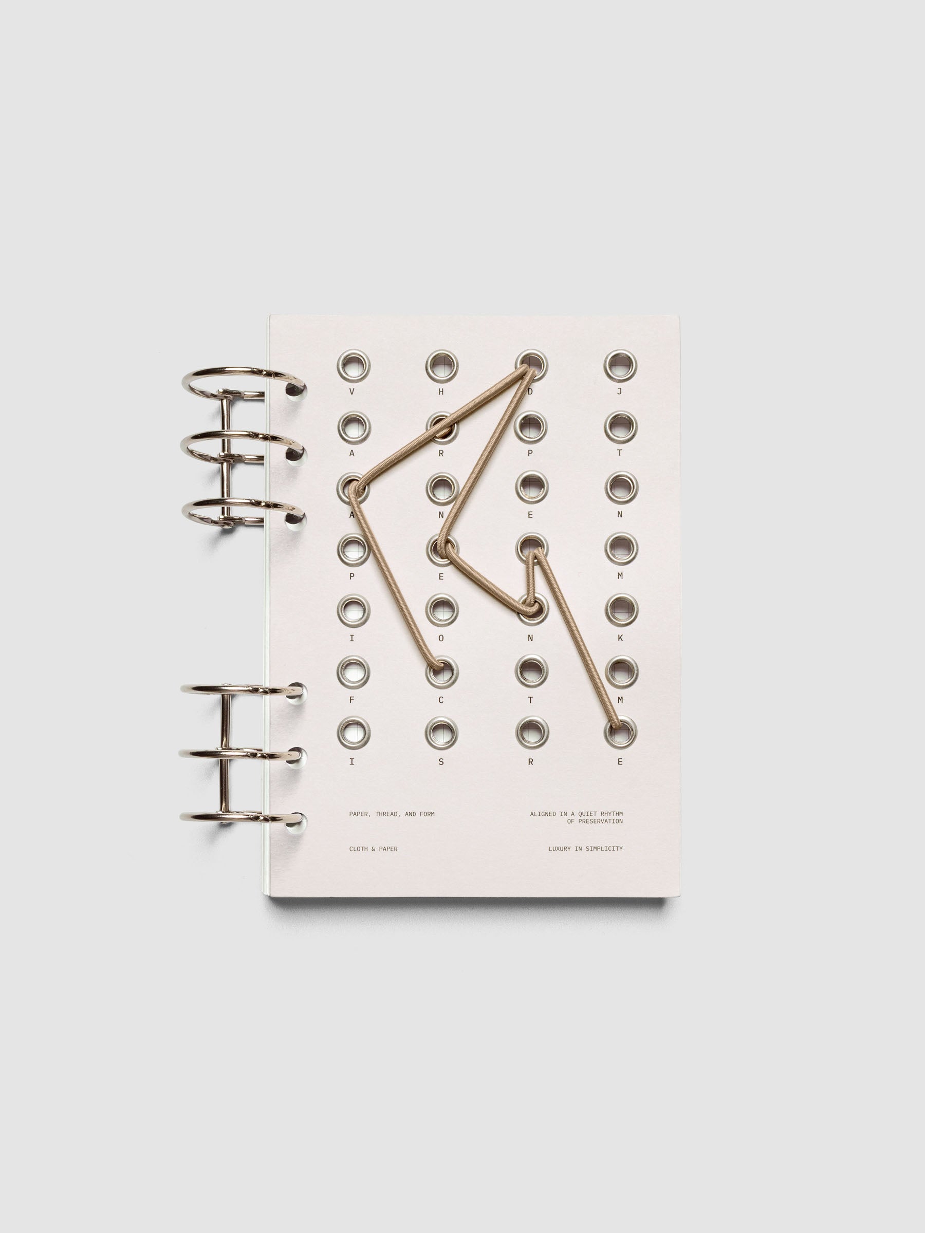 Cadence Dashboard with grommets and string on beige cardstock shown in size Personal Wide for 6-ring planners and notebooks.