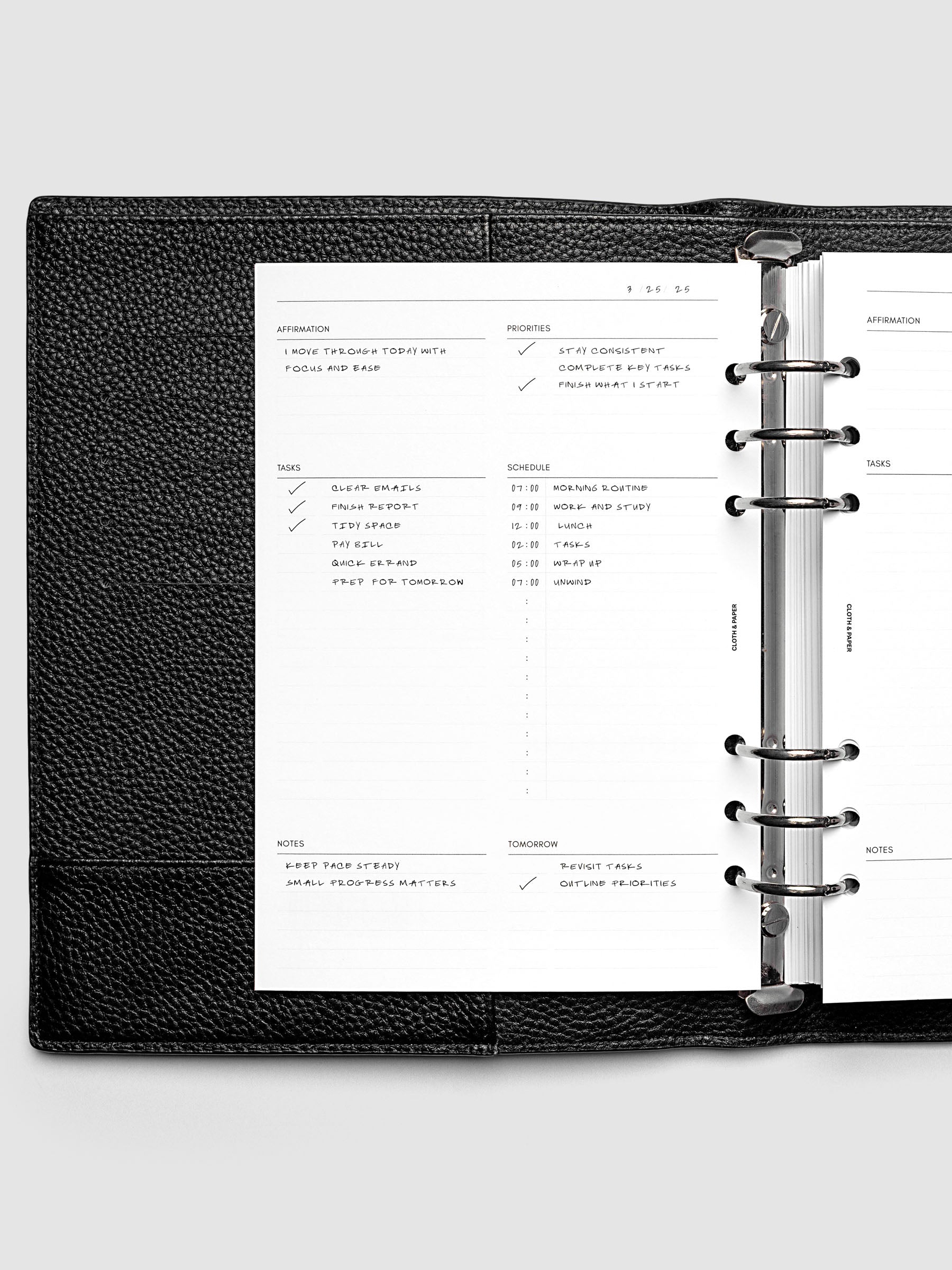 Demo page for the Daily Essentials Planner Inserts shown in size A5 inside a black agenda.