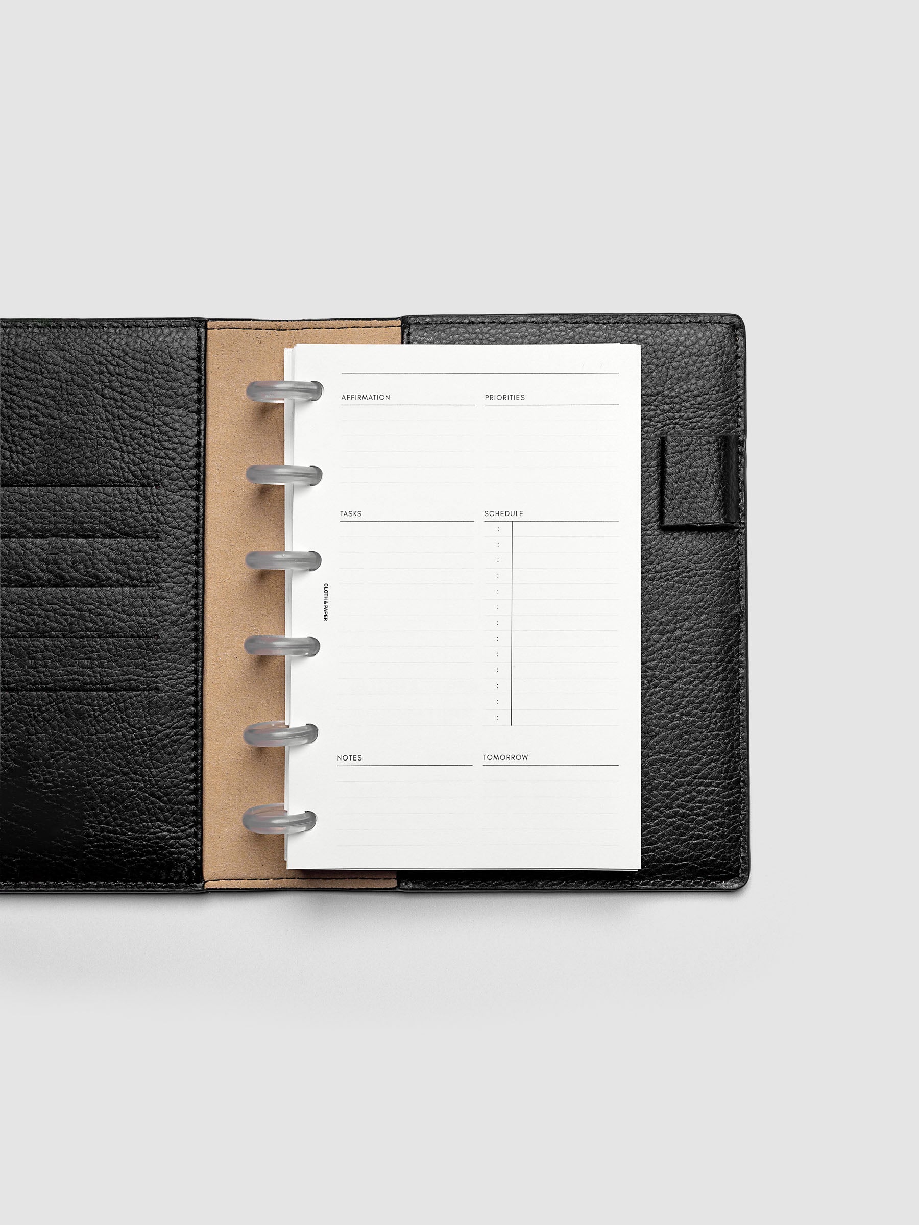 Daily Essentials Planner Inserts shown in size CP Petite inside a black folio.