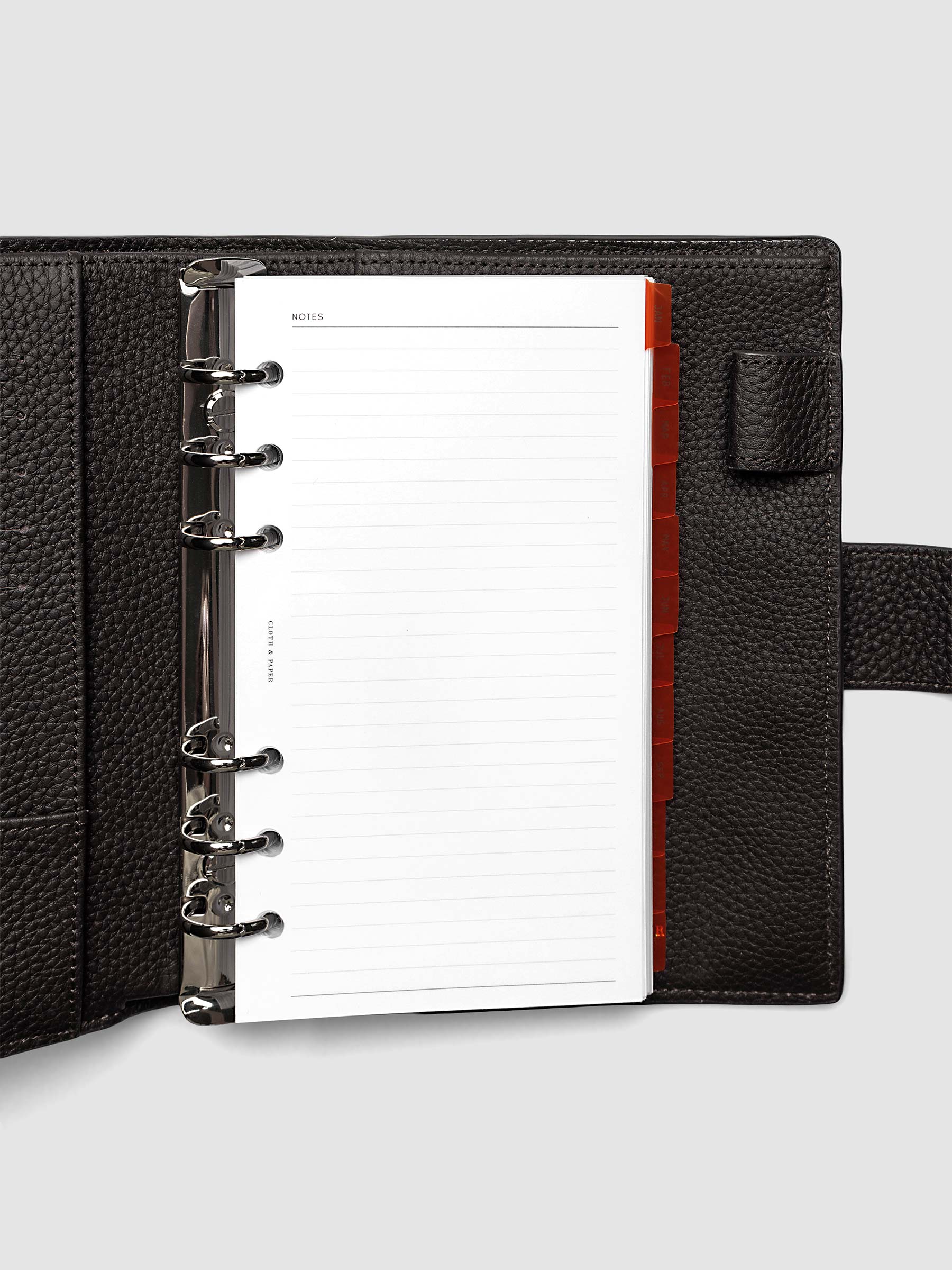 Personal 6-Ring Punch Ultra-Thin Monthly Dividers in deep orange shown tabbed inside a planner