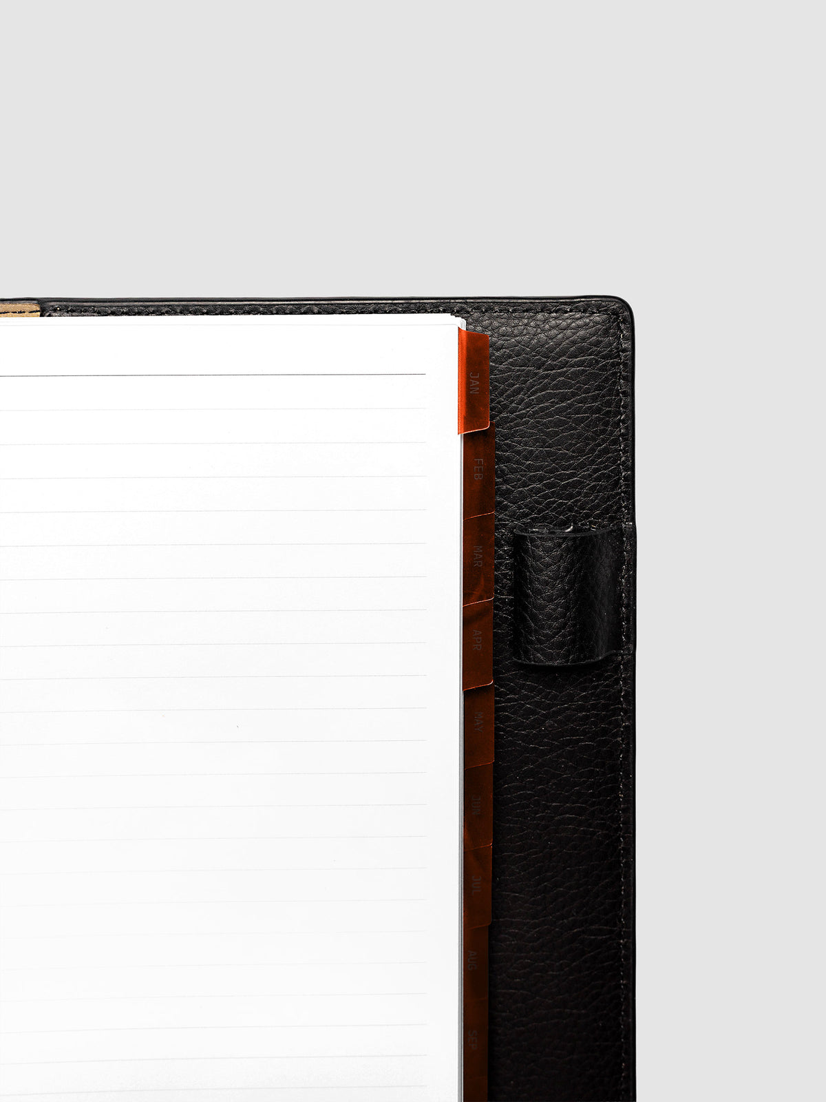 Top right corner close-up of deep orange monthly divider in Half Letter 8-Disc Punch planner showing tab label detail