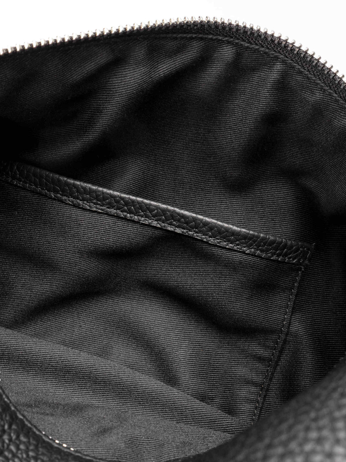 Folded Form Pouch close-up of silver snap hardware on side panel with leather zipper pull and silver zipper visible above