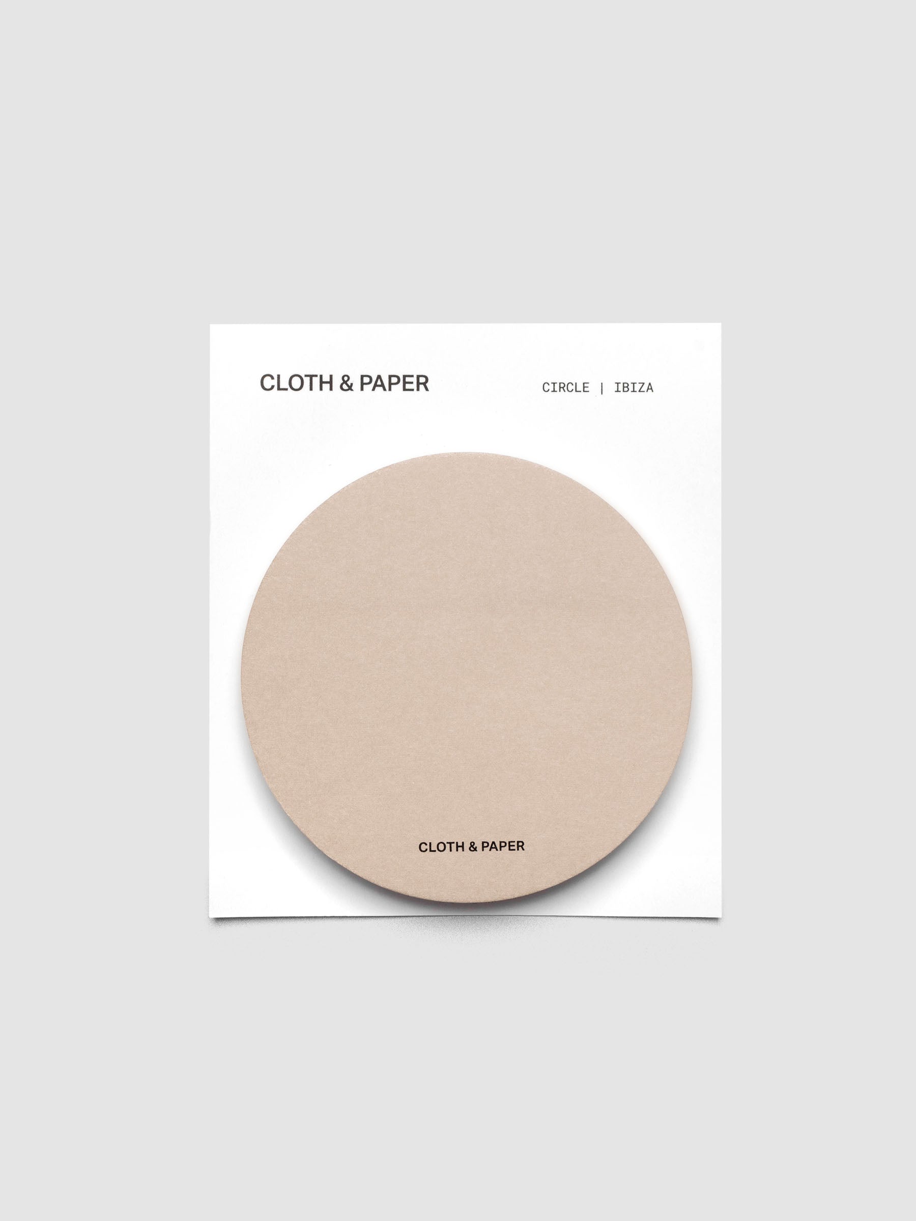 A stack of tan circular sticky notes on a white backer card