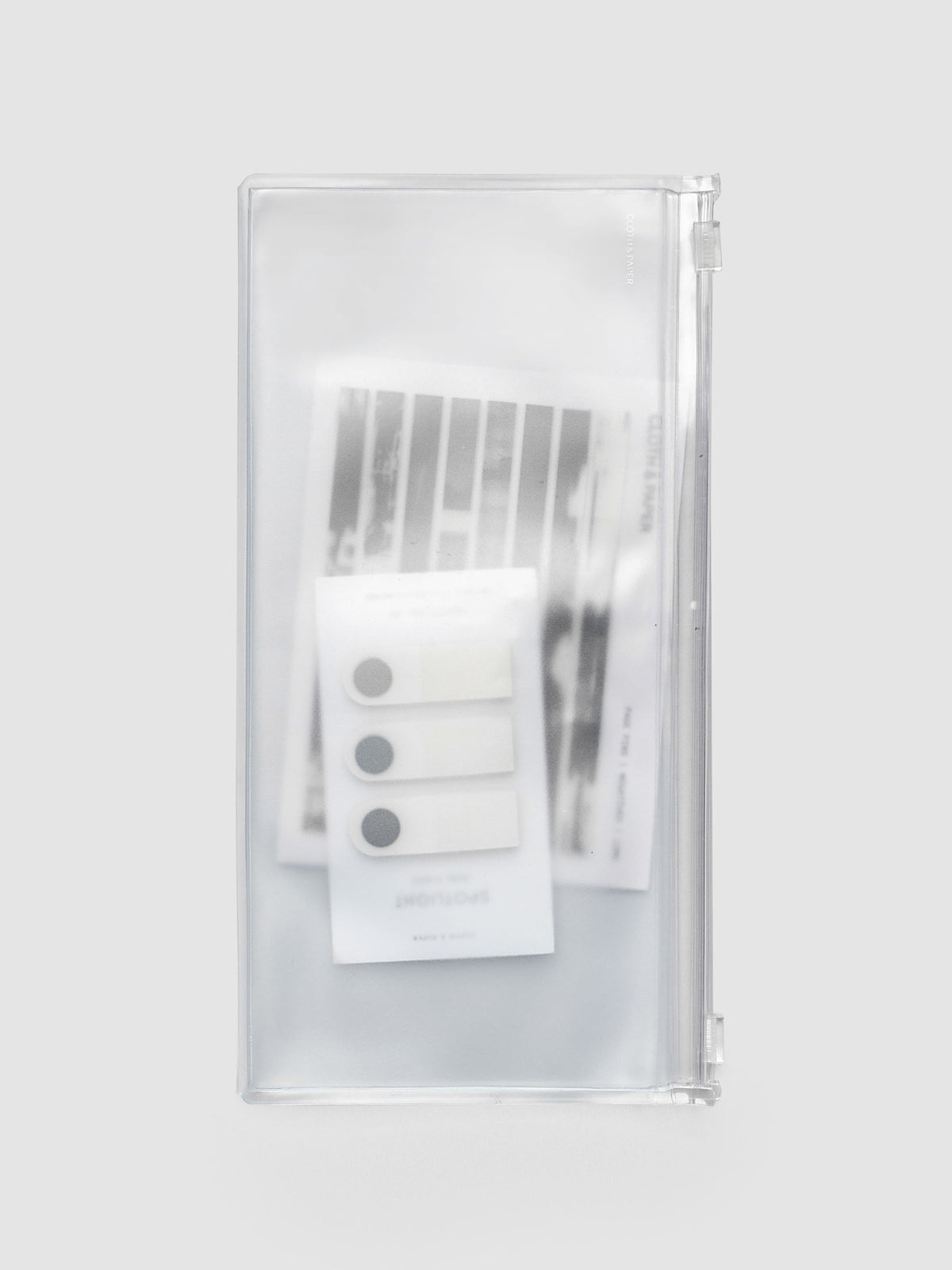 Storage Holder Travel Notebook A5 Slim closed with page pins and page flags inside, frosted clear plastic with silver foil logo