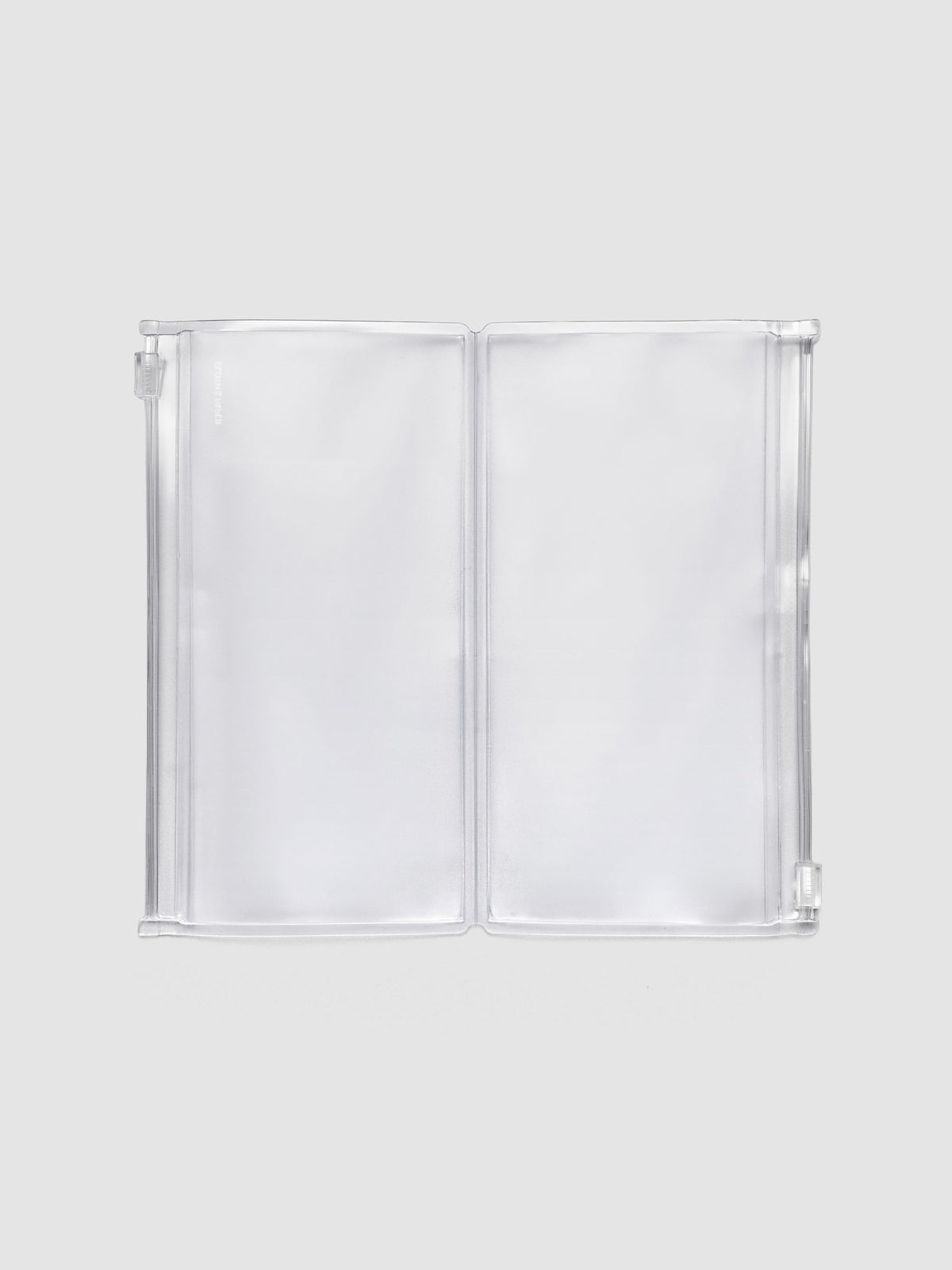 Pocket Plus travel notebook storage holder in clear frosted plastic, open, showing two zippered pouches