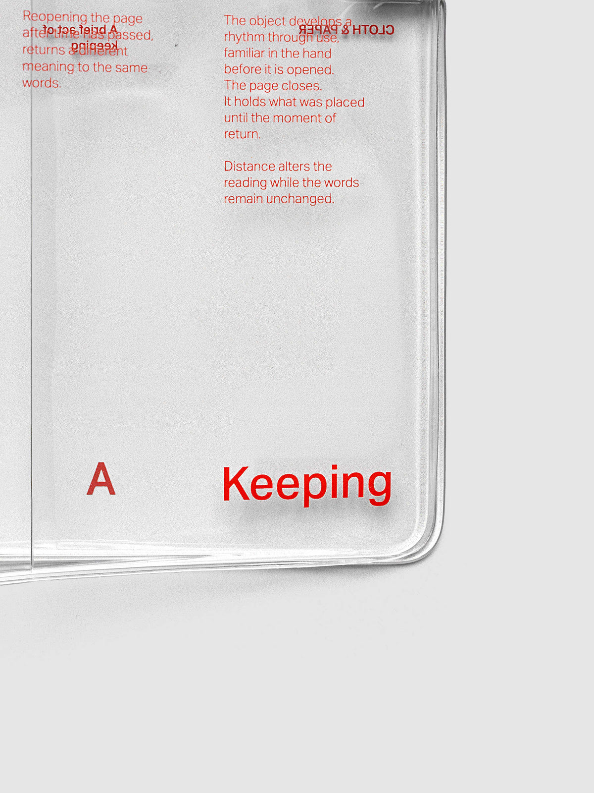 Close-up of the bottom right corner of the Act of Keeping Travel Notebook Cover in A5 Slim size, closed, showing metal tab closure and deep orange text