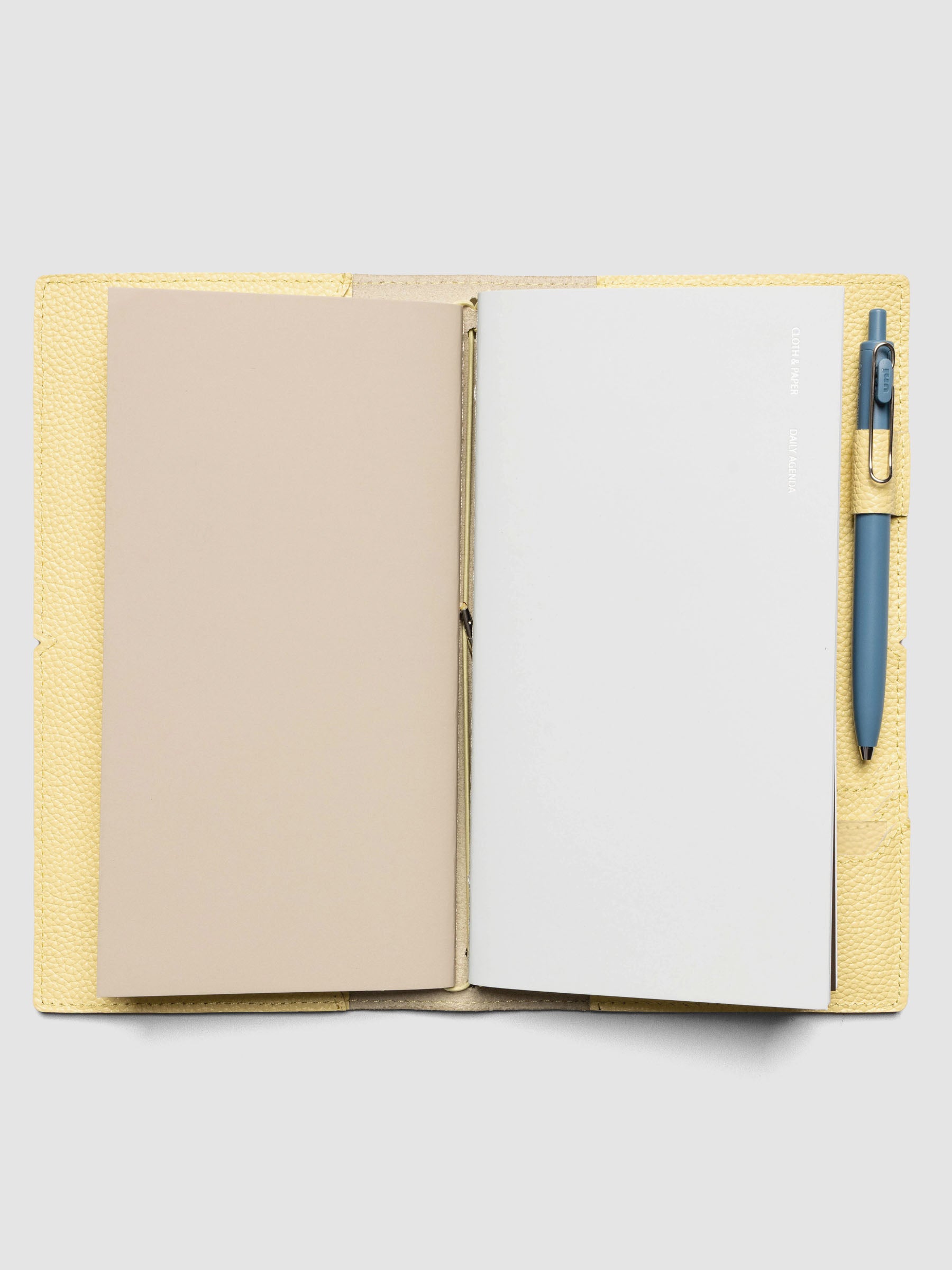 Butter yellow leather travel notebook cover in size A5 Slim shown with travel notebooks inside.