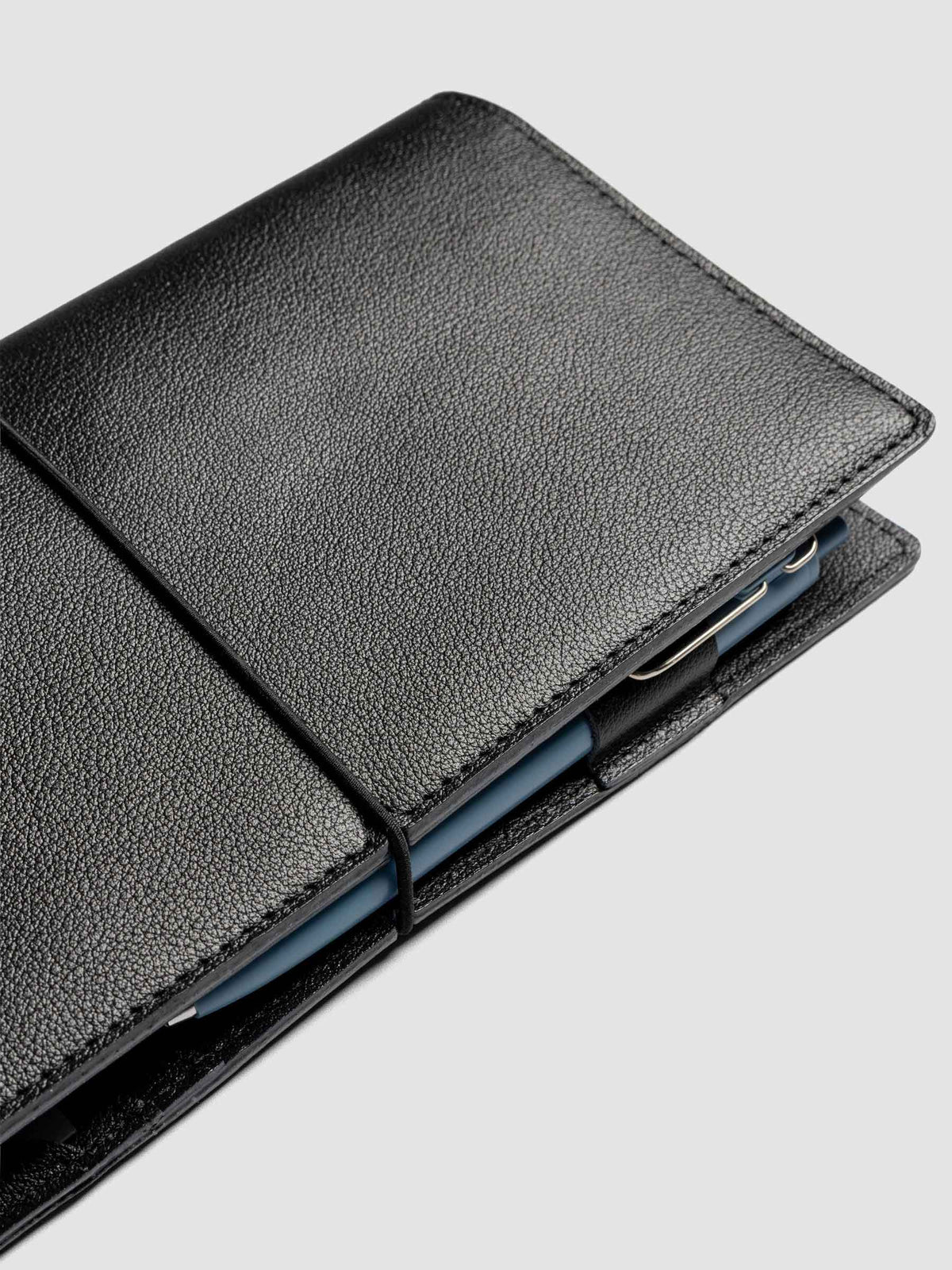 Black leather travel notebook cover in size A5 Slim shown closed.