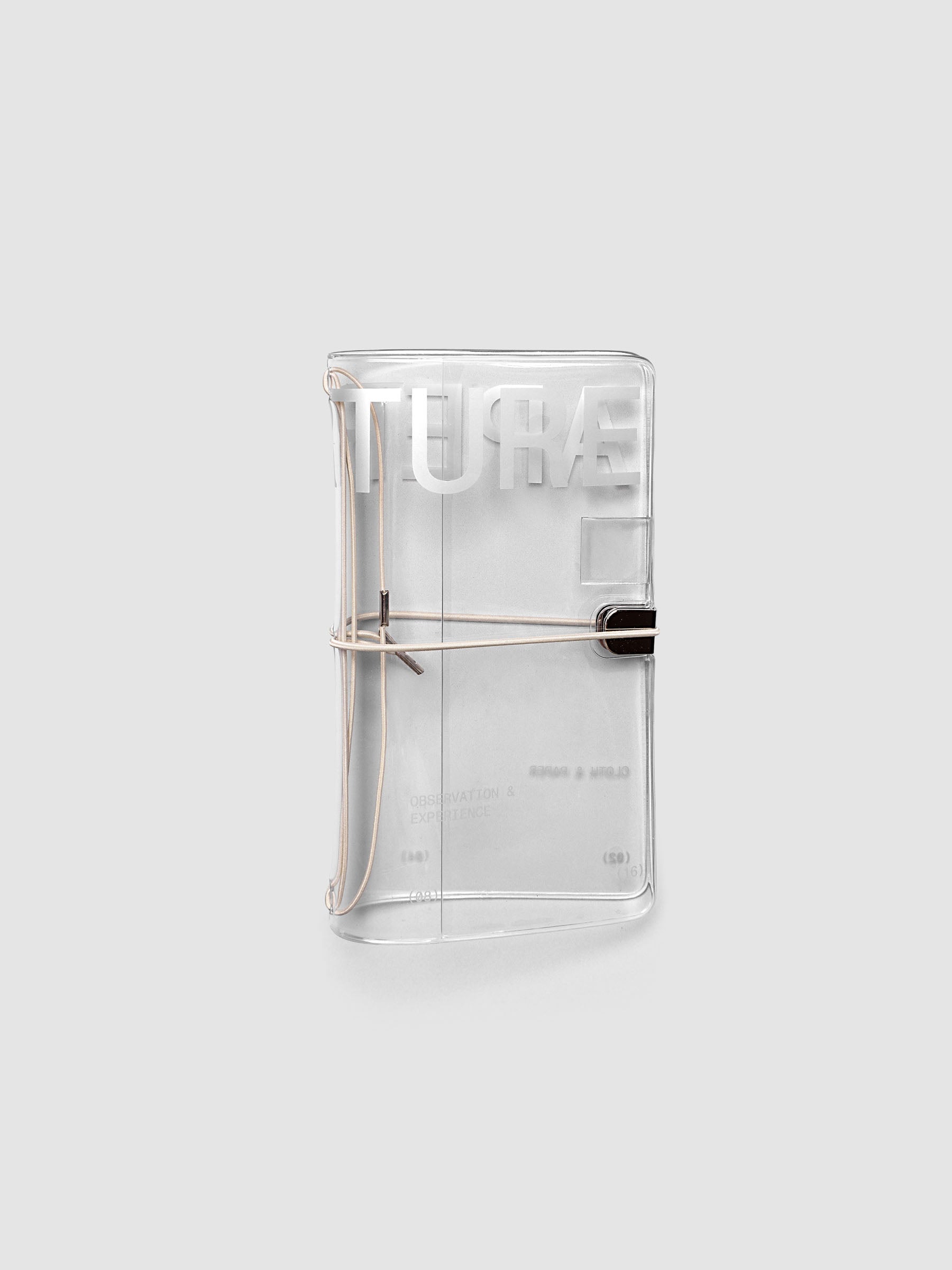 Aperture Travel Notebook Cover in Pocket Plus size, closed, in clear vinyl with silver typographic print and metal tab closure