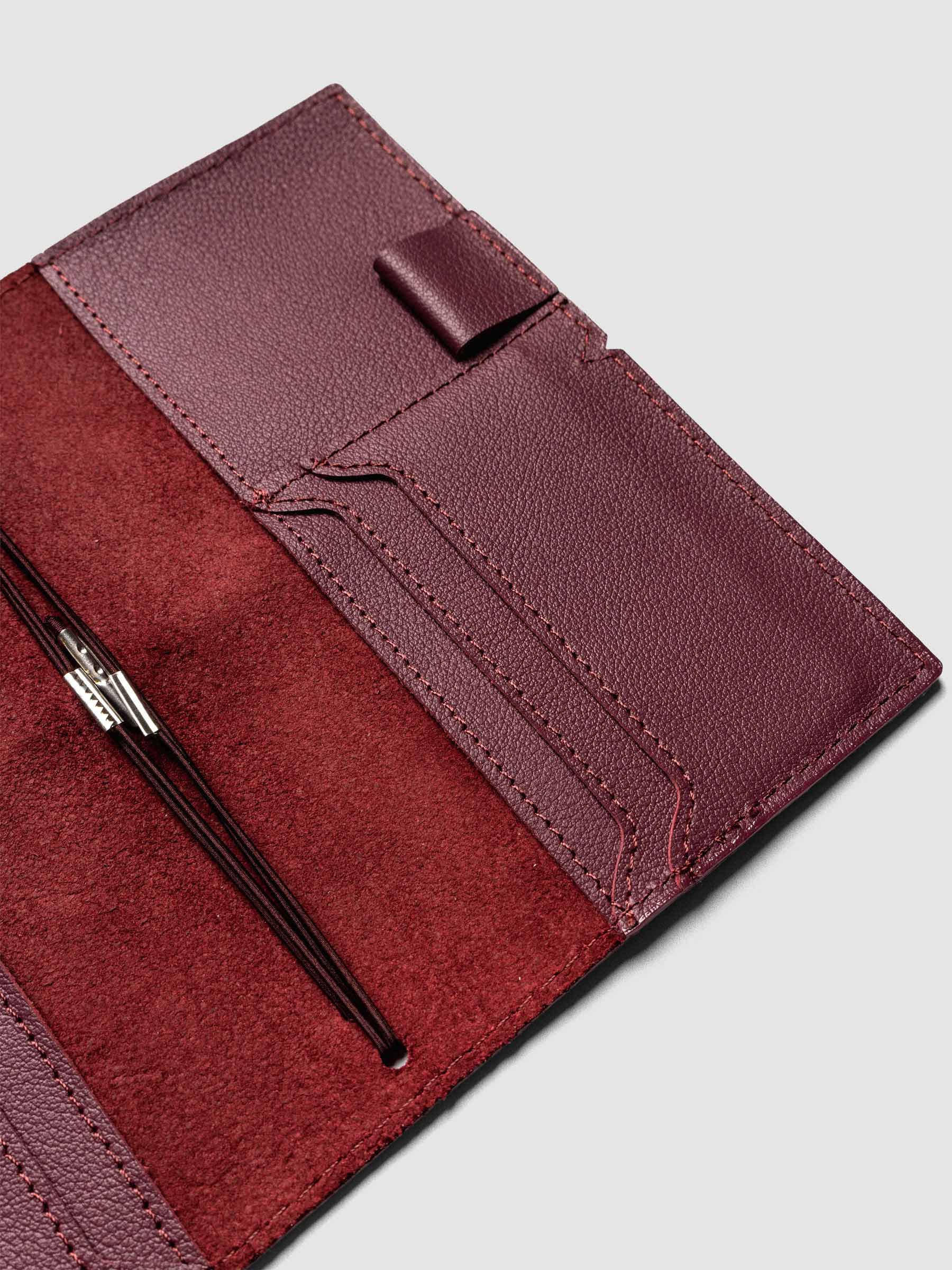Deep red leather travel notebook cover in size Pocket Plus shown open with interior pockes and elastic bands.