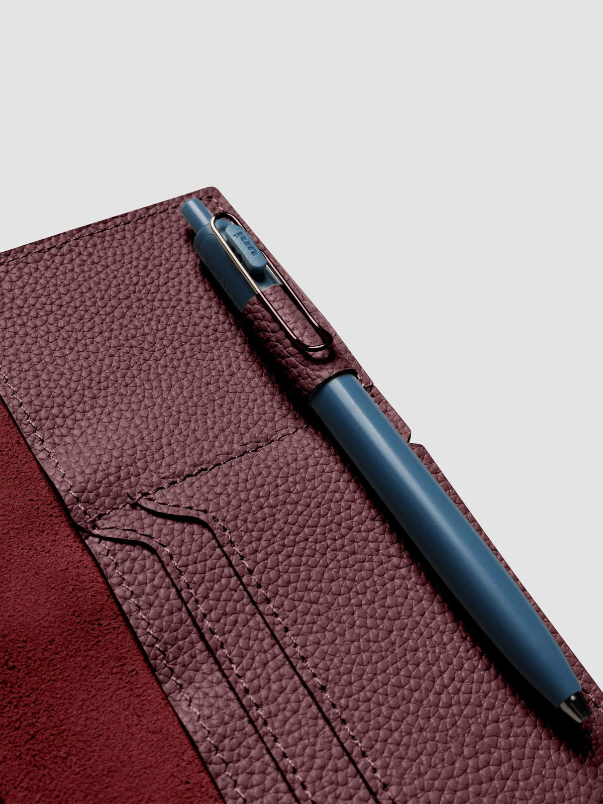 Deep red leather travel notebook cover in size Pocket Plus shown open with a pen in the pen loop.