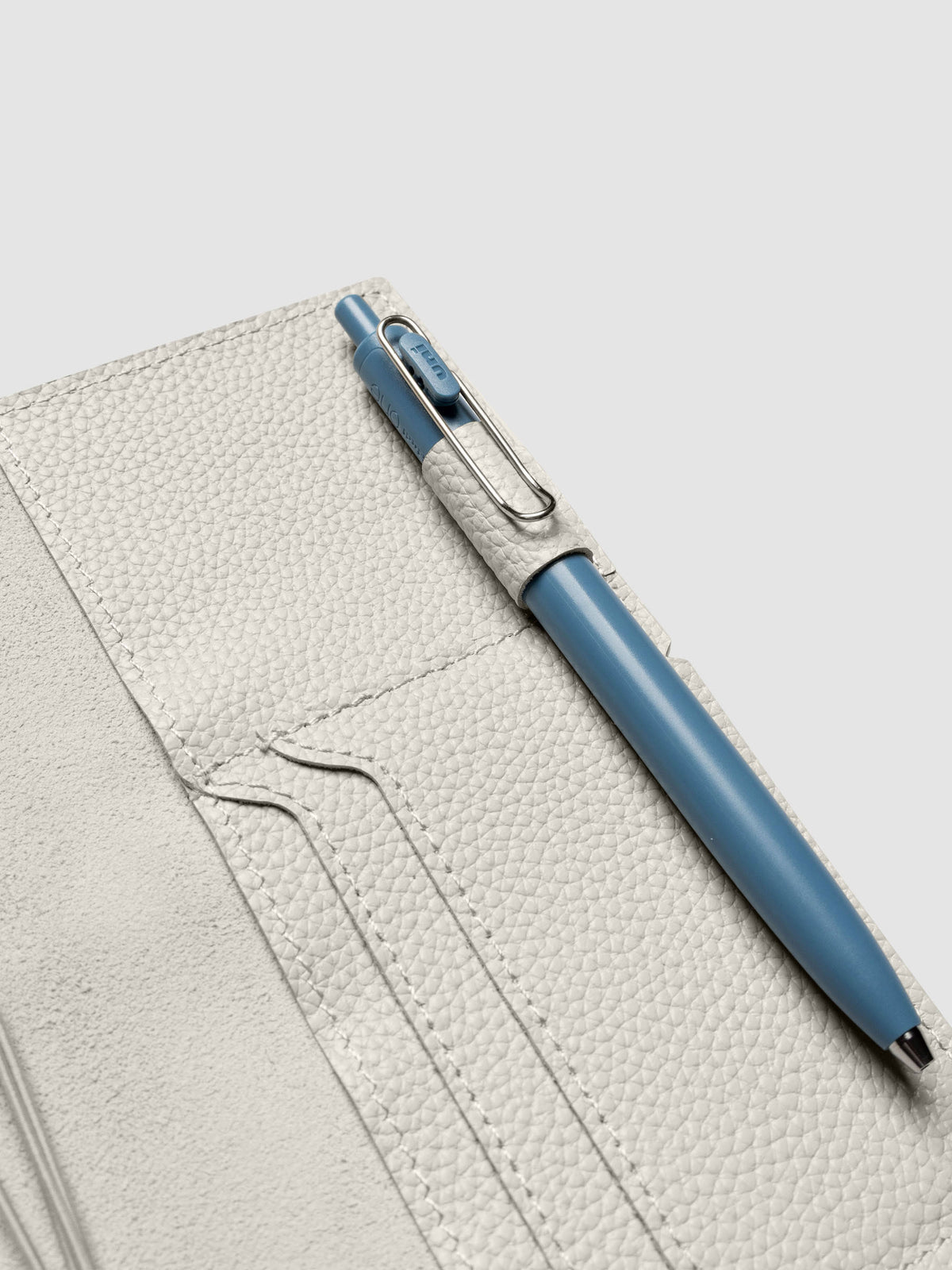 Light grey leather travel notebook cover in size Pocket Plus shown with travel notebooks inside.