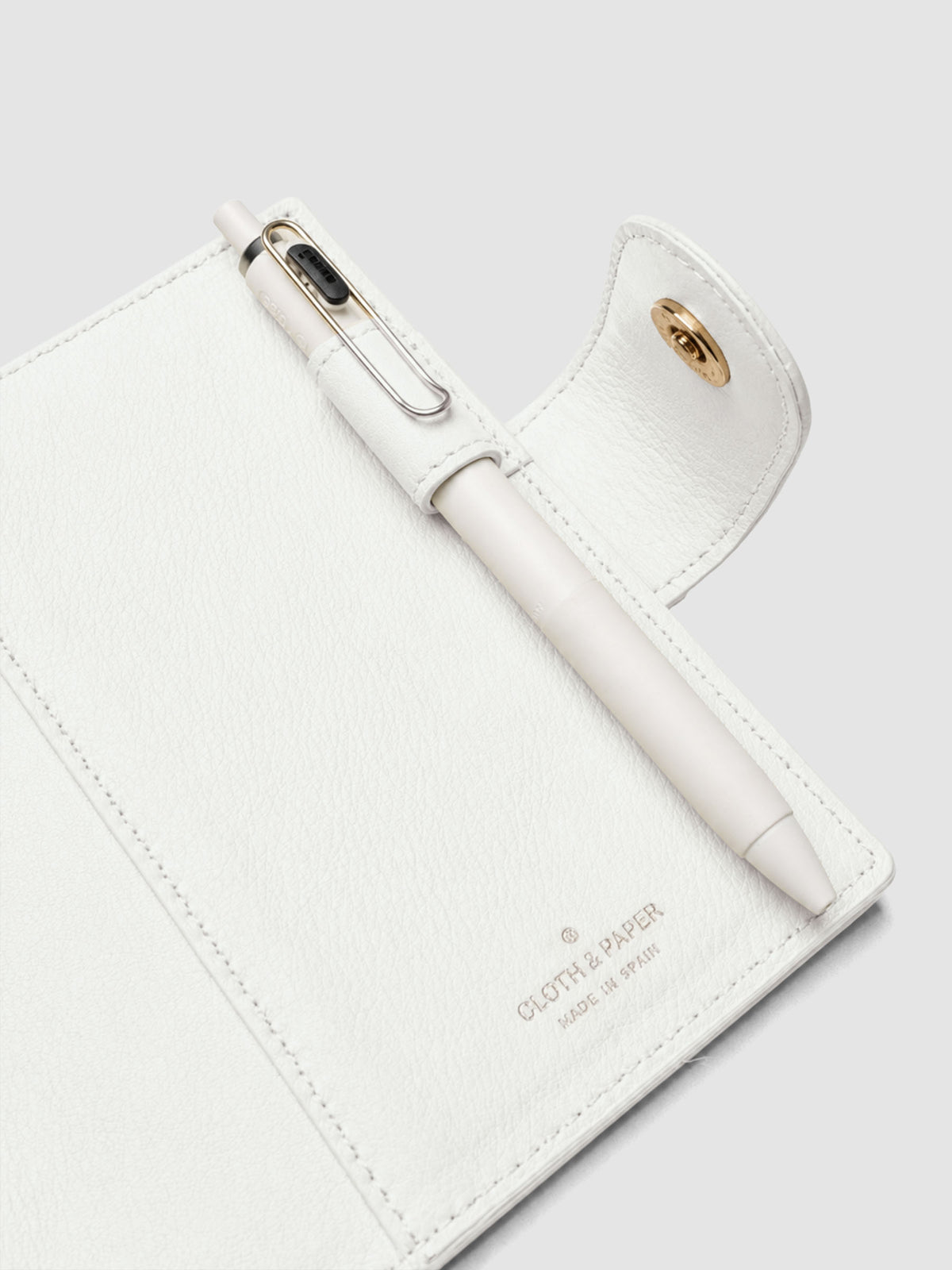 Heirloom Ring Cover Genuine Leather Pocket 6-Ring Punch in off-white, detail view of interior pen loop, large pocket, and closure with pen in pen loop