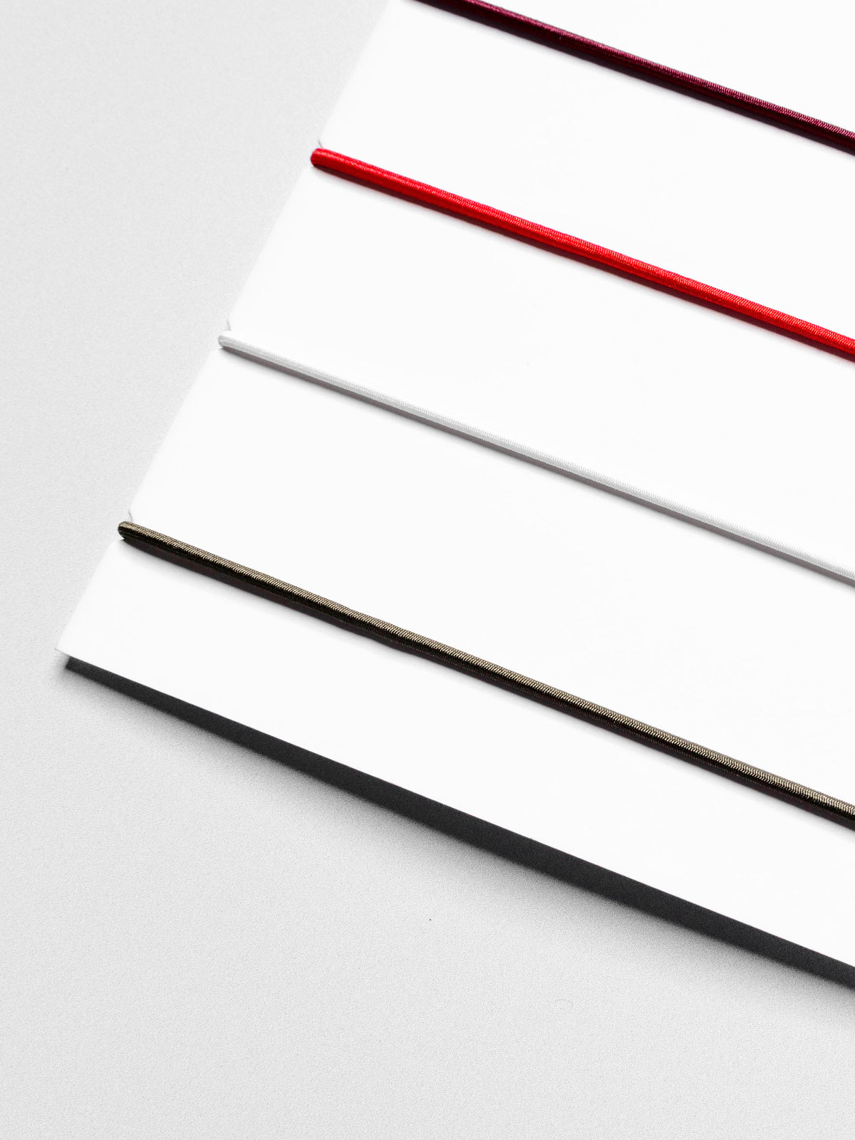 Closeup of travel bands displayed in their packaging on a neutral background.