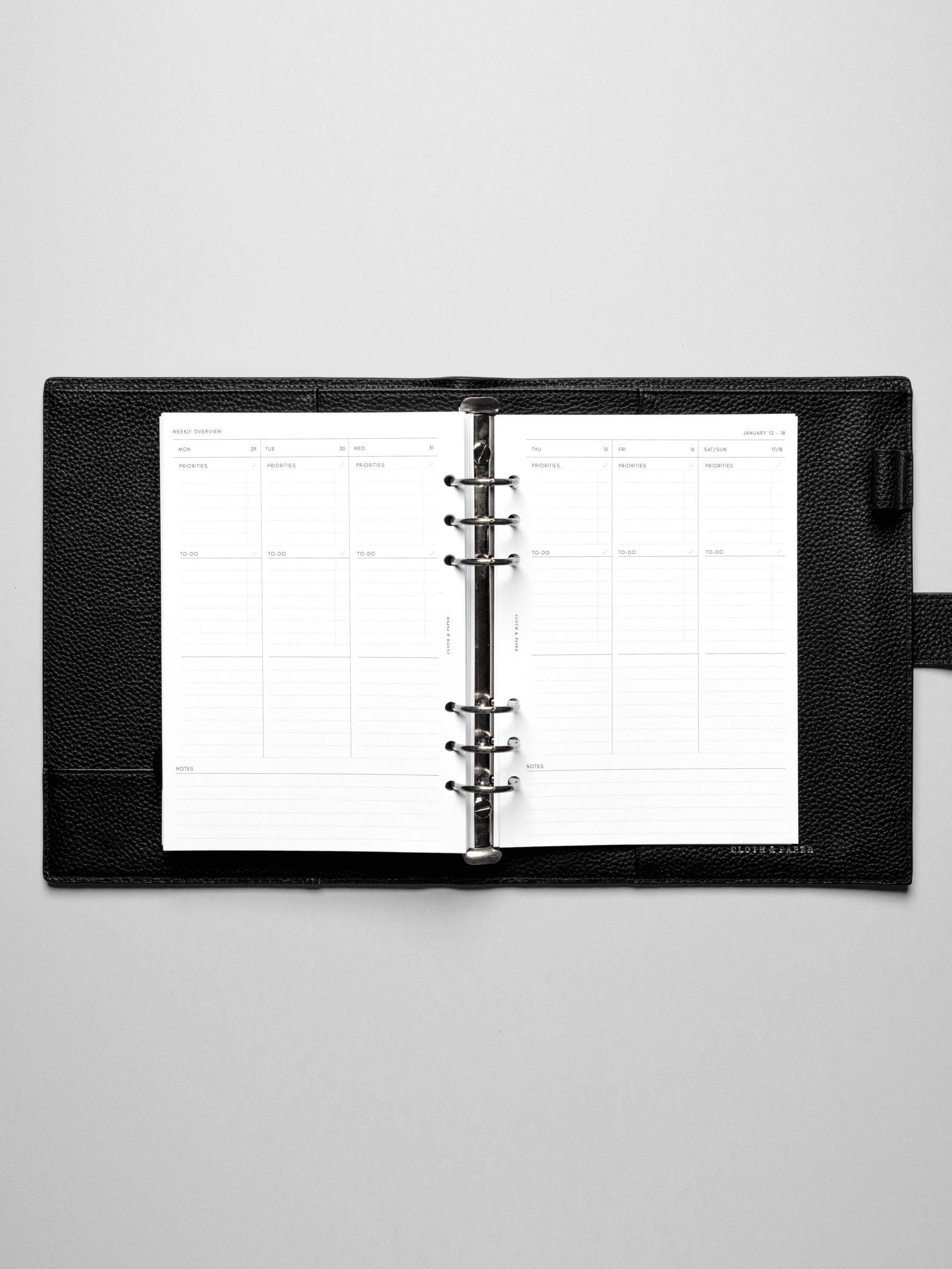 The Monday Start 2026 Dated Weekly Task Planner Insert in a black leather ring-bound notebook.