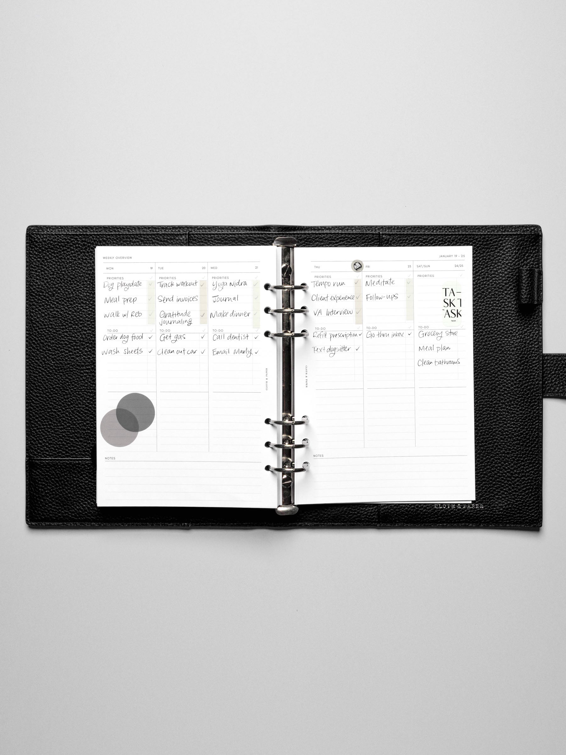 The Monday Start 2026 Dated Weekly Task Planner Insert in a black leather ring-bound notebook.