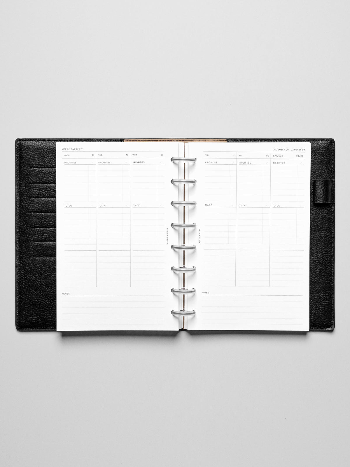 The Monday Start 2026 Dated Weekly Task Planner Insert in a black leather disc-bound notebook.