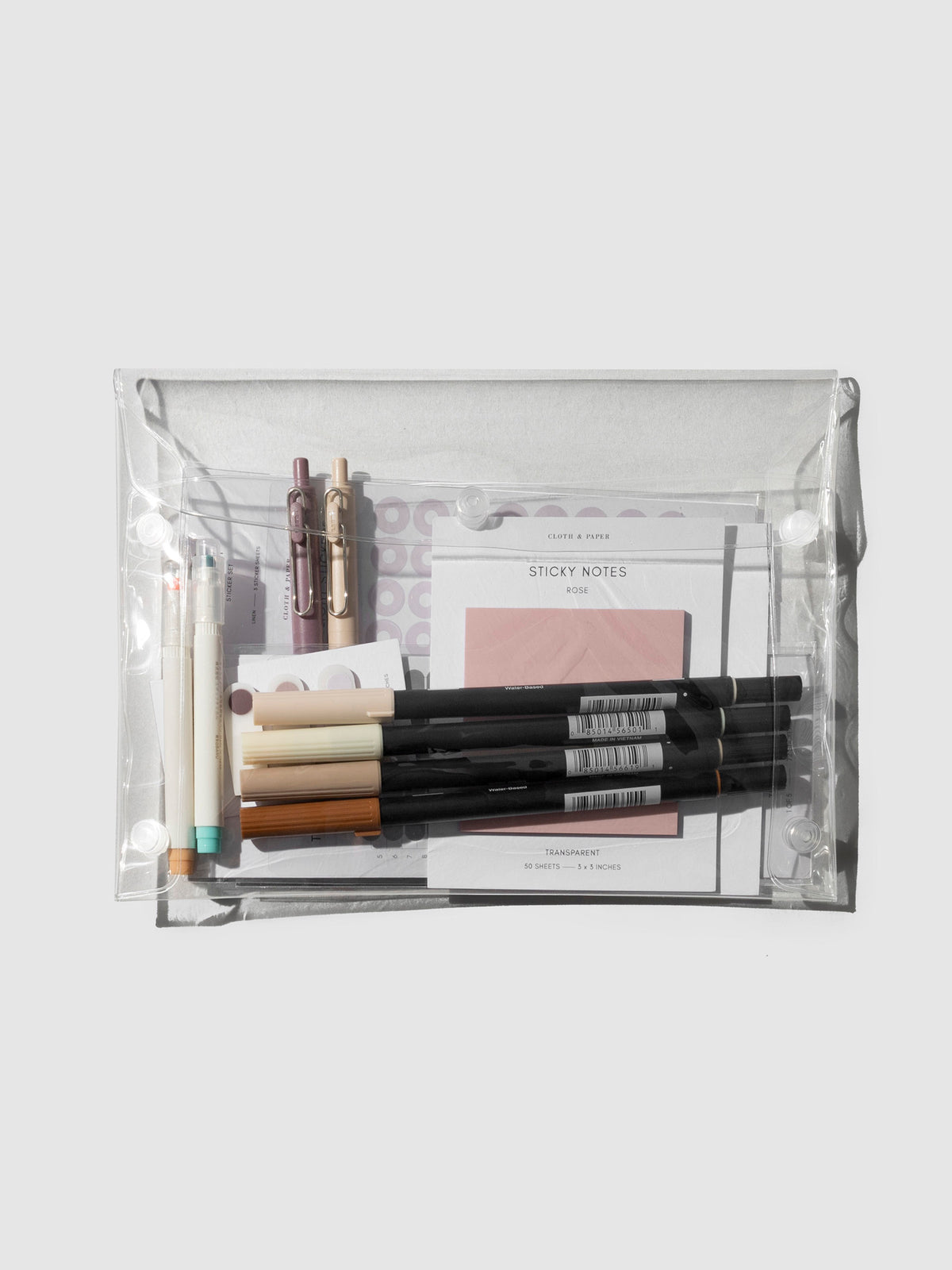 Pouch displayed on a neutral background. It is filled with pens, stickers, and sticky notes.