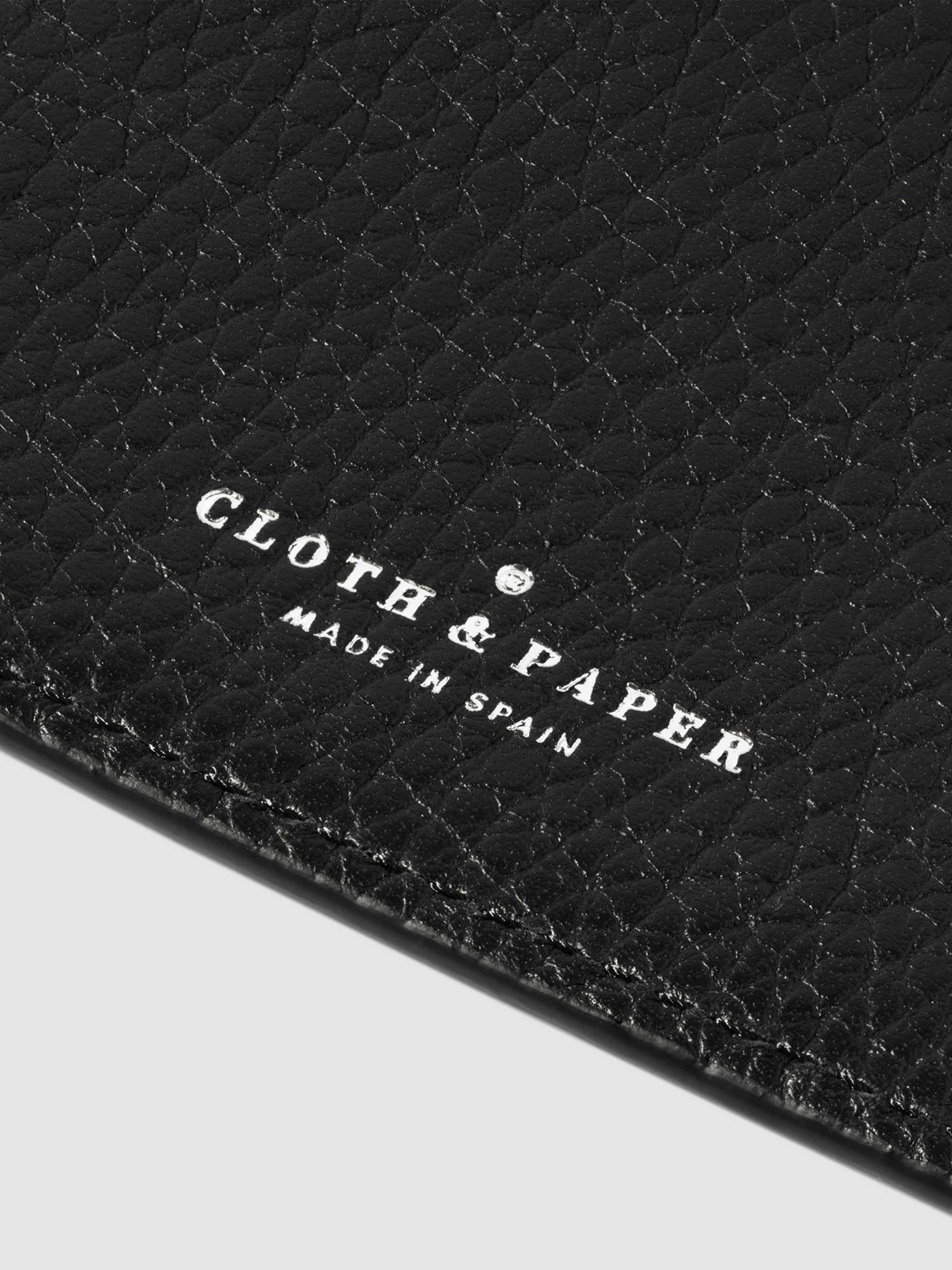 Closeup of silver embossed Cloth and Paper logo in a black leather folio.