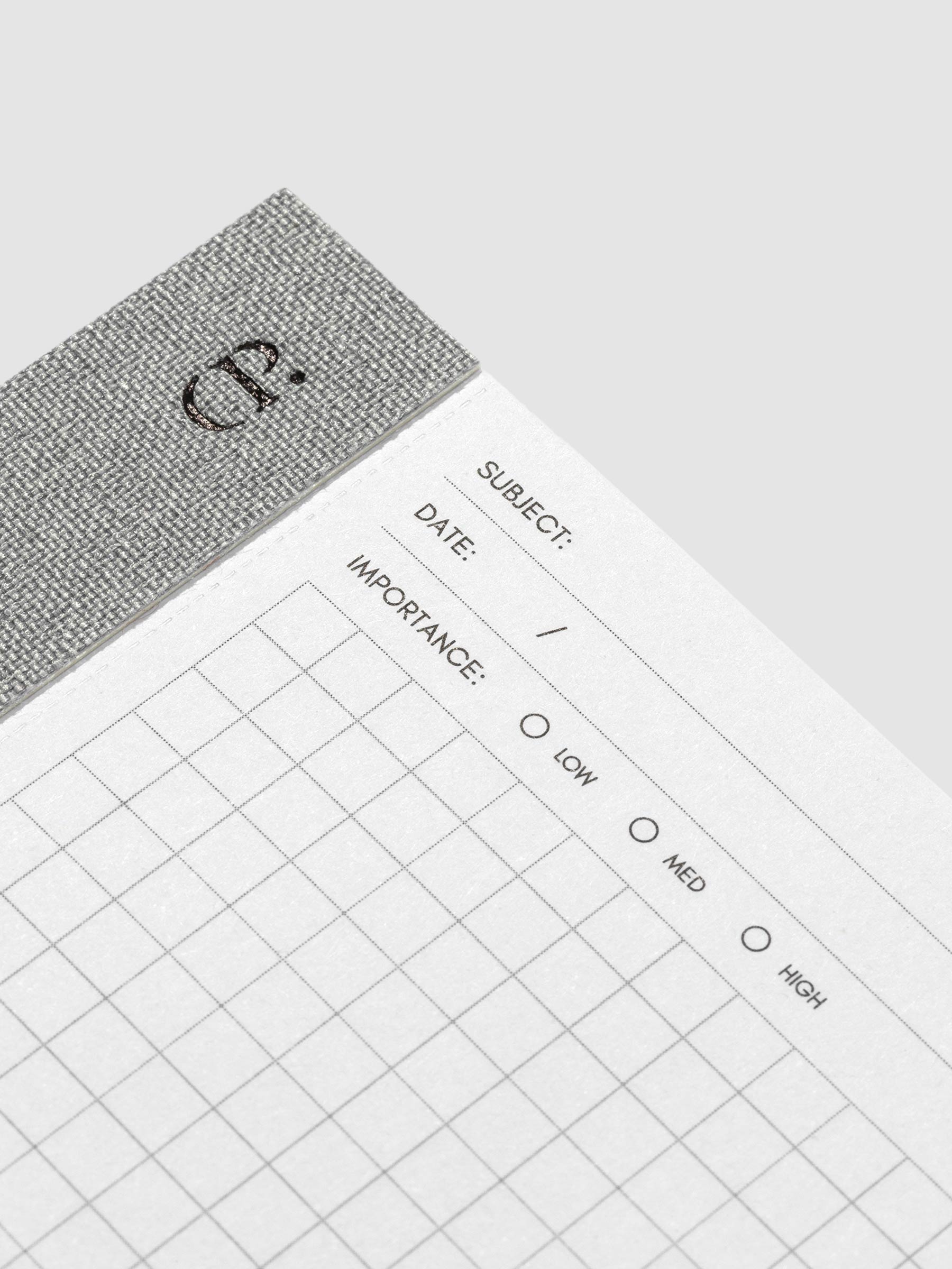 Closeup of the top left corner of the notepad. The Cloth and Paper CP logo is visible alongside the subject, date, and importance headers on the notepad.