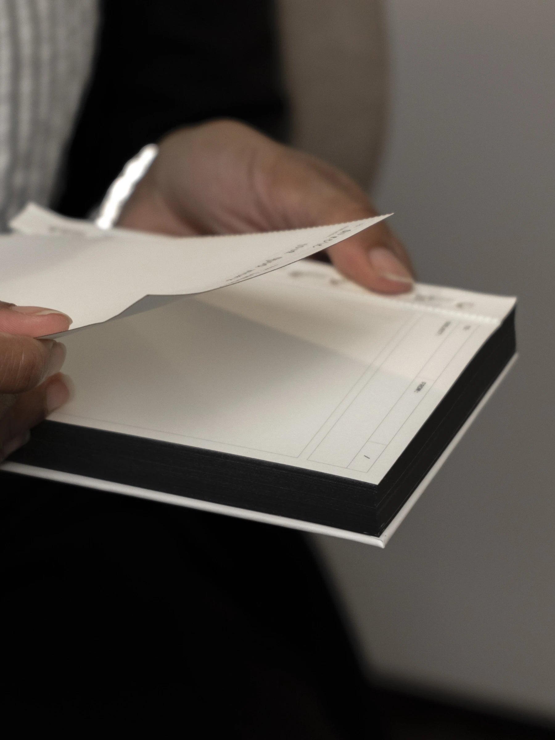 Hands tearing a sheet off the Message Pad.