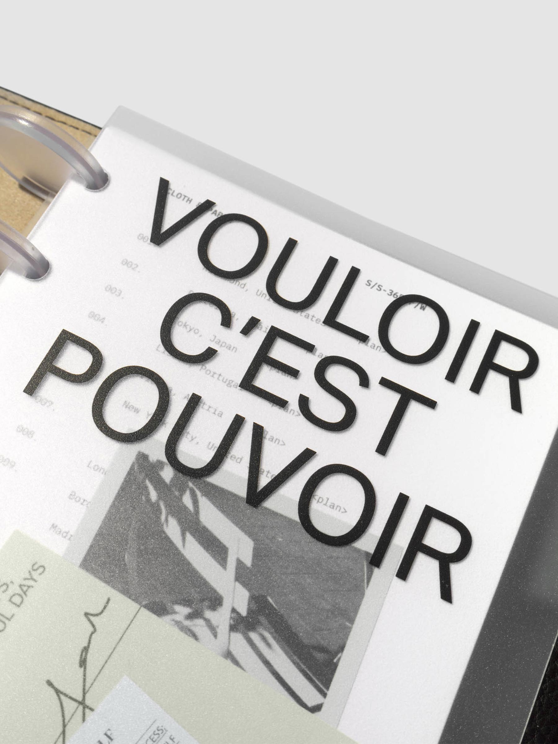 Close up image of the top right corner of the Moments Cover and Dashboard displayed in black folio with clear discs. The text reads Vouloir C'est Pouvoir. It is turned at a slight angle on a neutral background.
