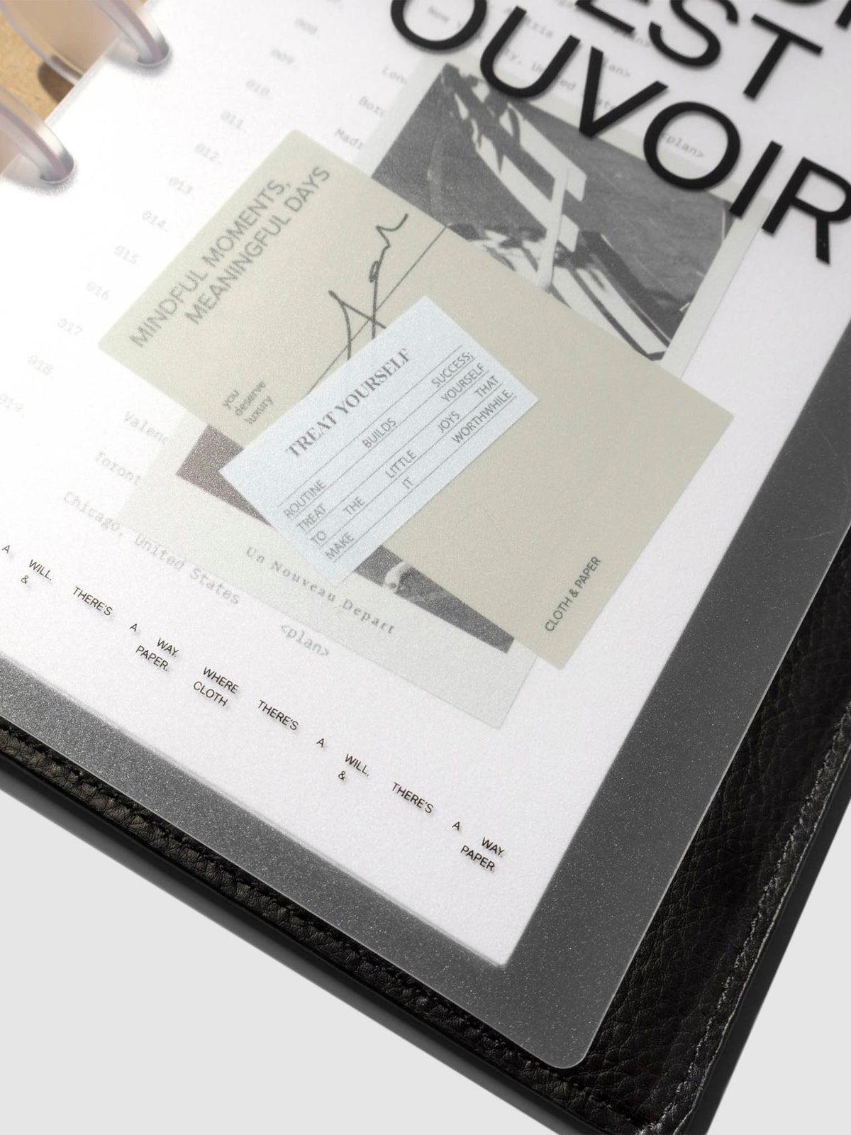 Close up image of the bottom of the Moments Cover and Dashboard displayed in a black folio with clear discs turned at a slight angle on a neutral background.