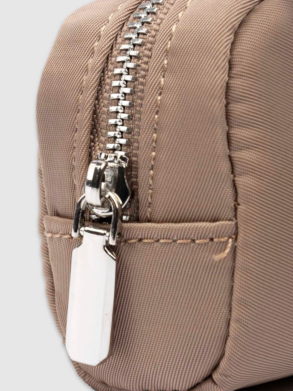 Closeup of pencil pouch's zipper. Color featured is fossil.