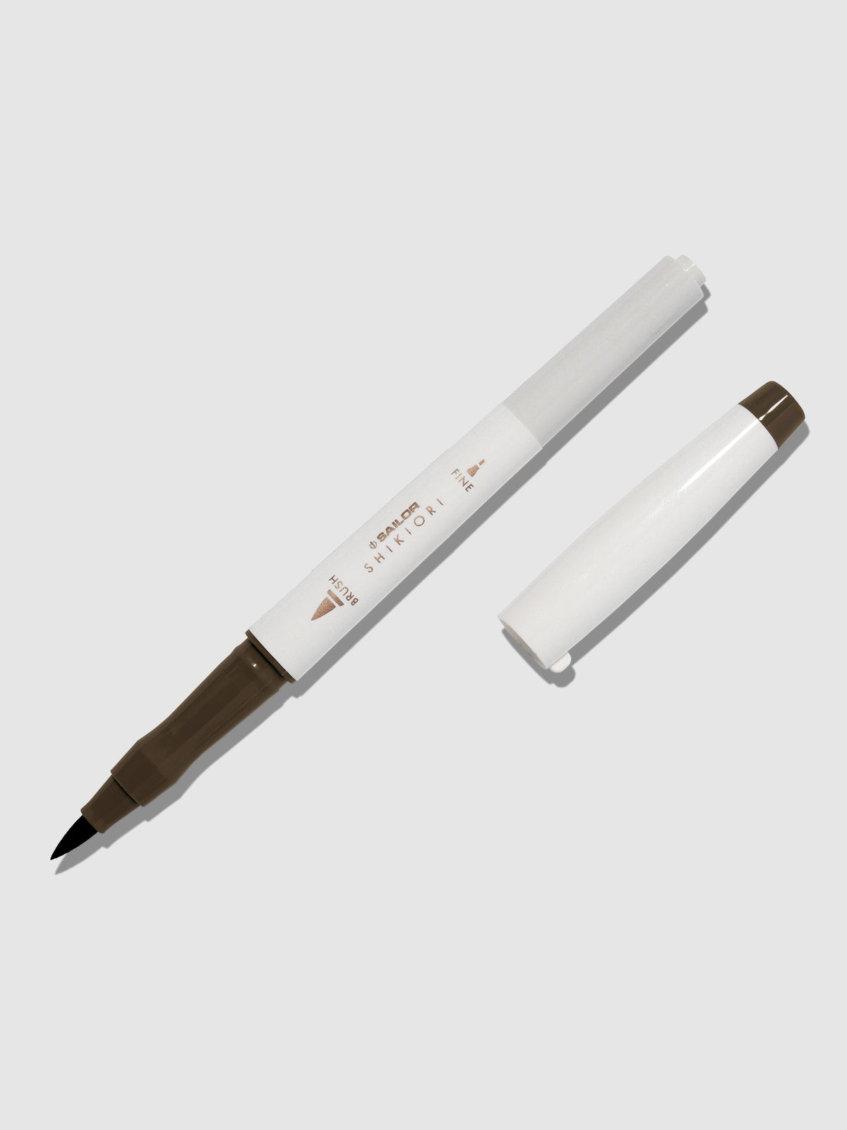 Brush pen displayed on a neutral background. It is uncapped with its brush nib exposed, and the cap lying parallel to the marker. Color pictured is Doyou.