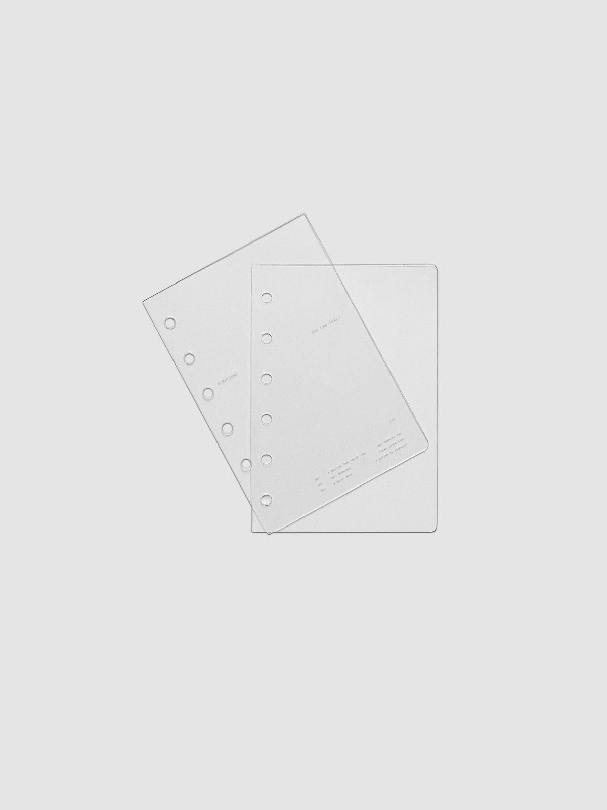 Pocket sized crystal clear plastic planner cover set with text printed on the cover on the theme of structure and routines.