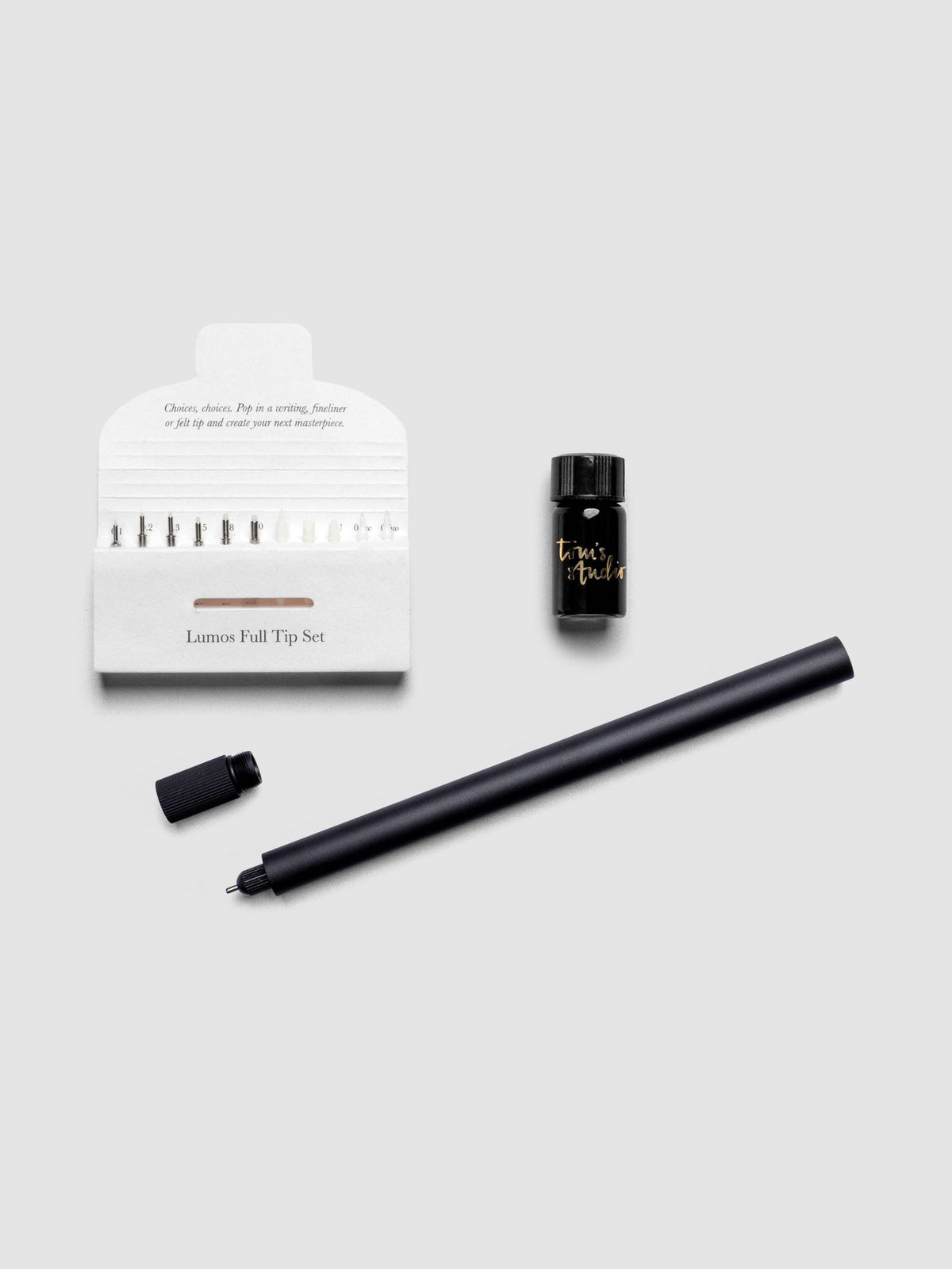 Tom’s Studio Lumos Pro Pen Single Tip Pen in Matte Black finish shown uncapped on a flat surface.