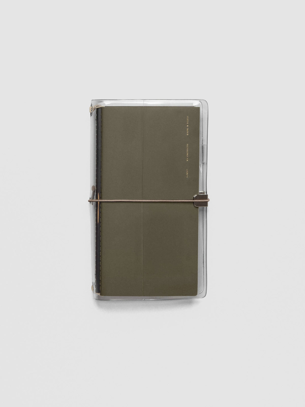 Taupe elastic band stretched across clear vinyl cover, anchored at metal clasp.