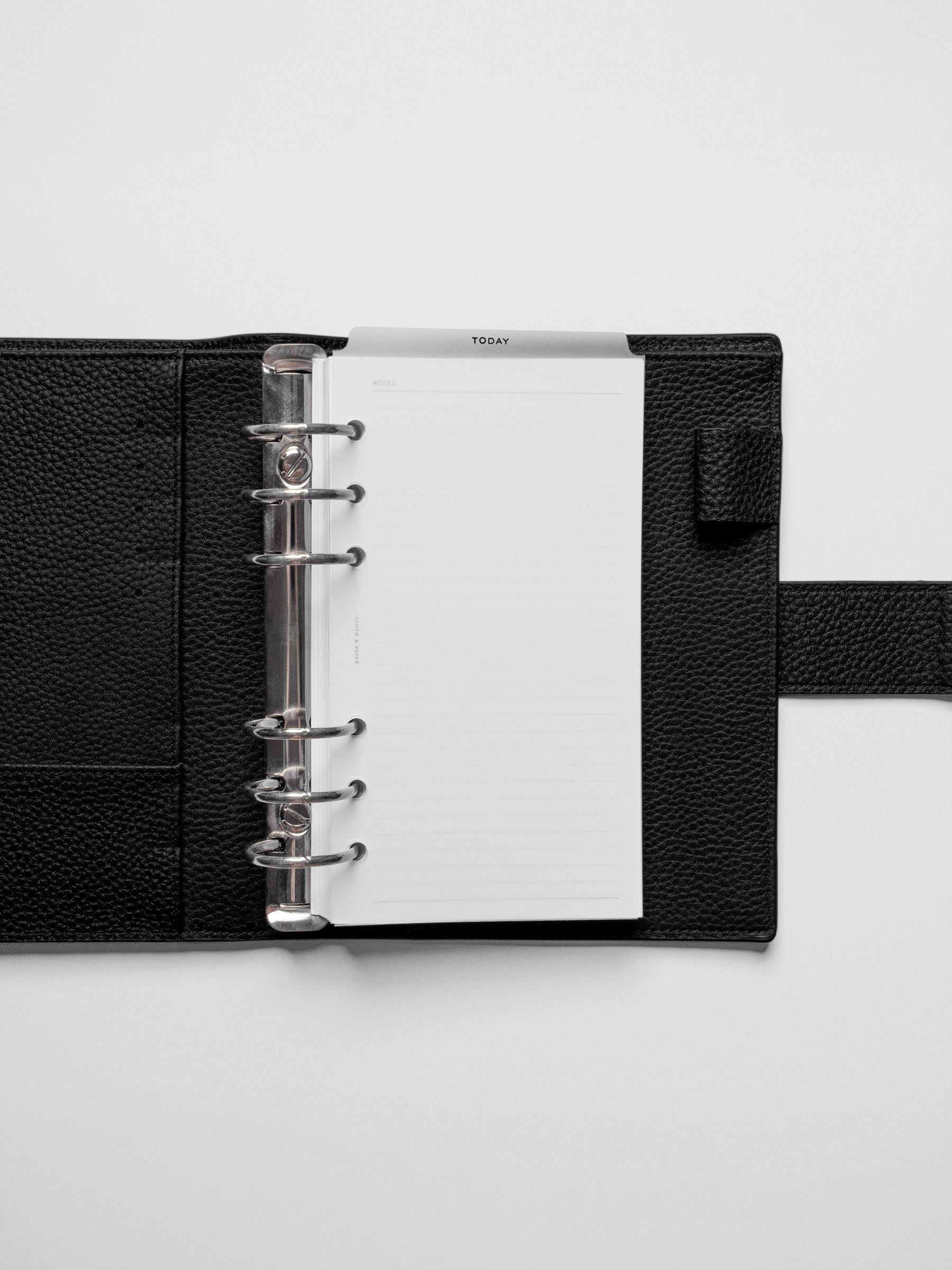 Black foil divider displayed in a black leather planner.