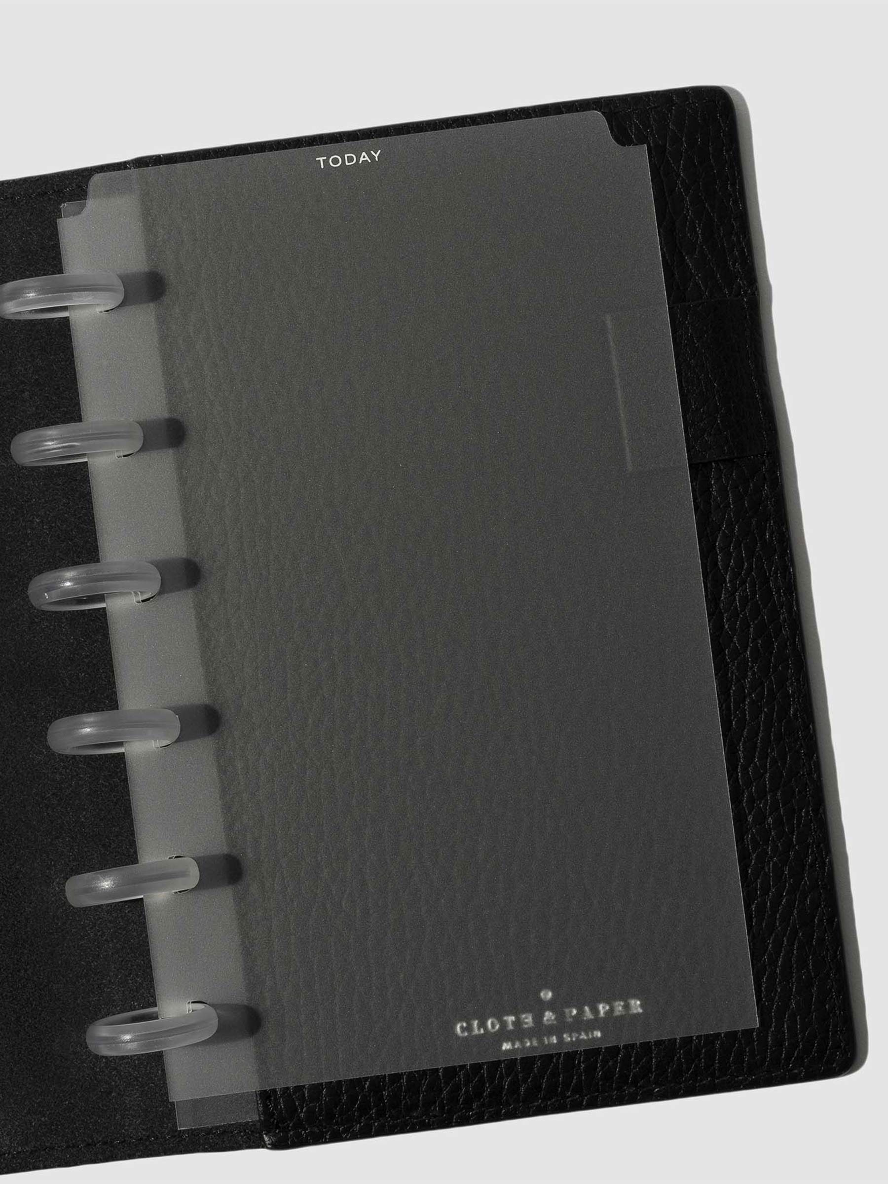 White foil divider displayed in a black leather planner.
