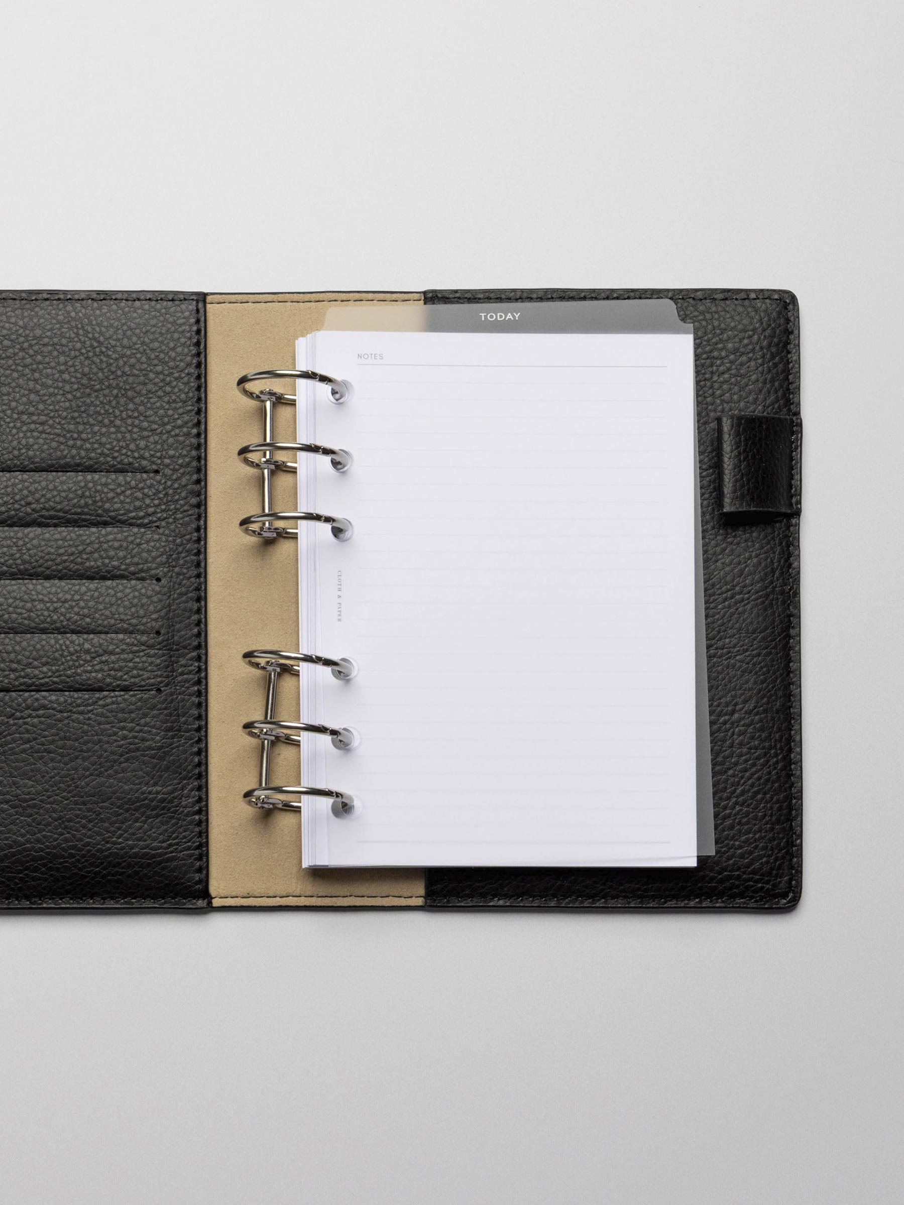 White foil divider displayed in a black leather planner.