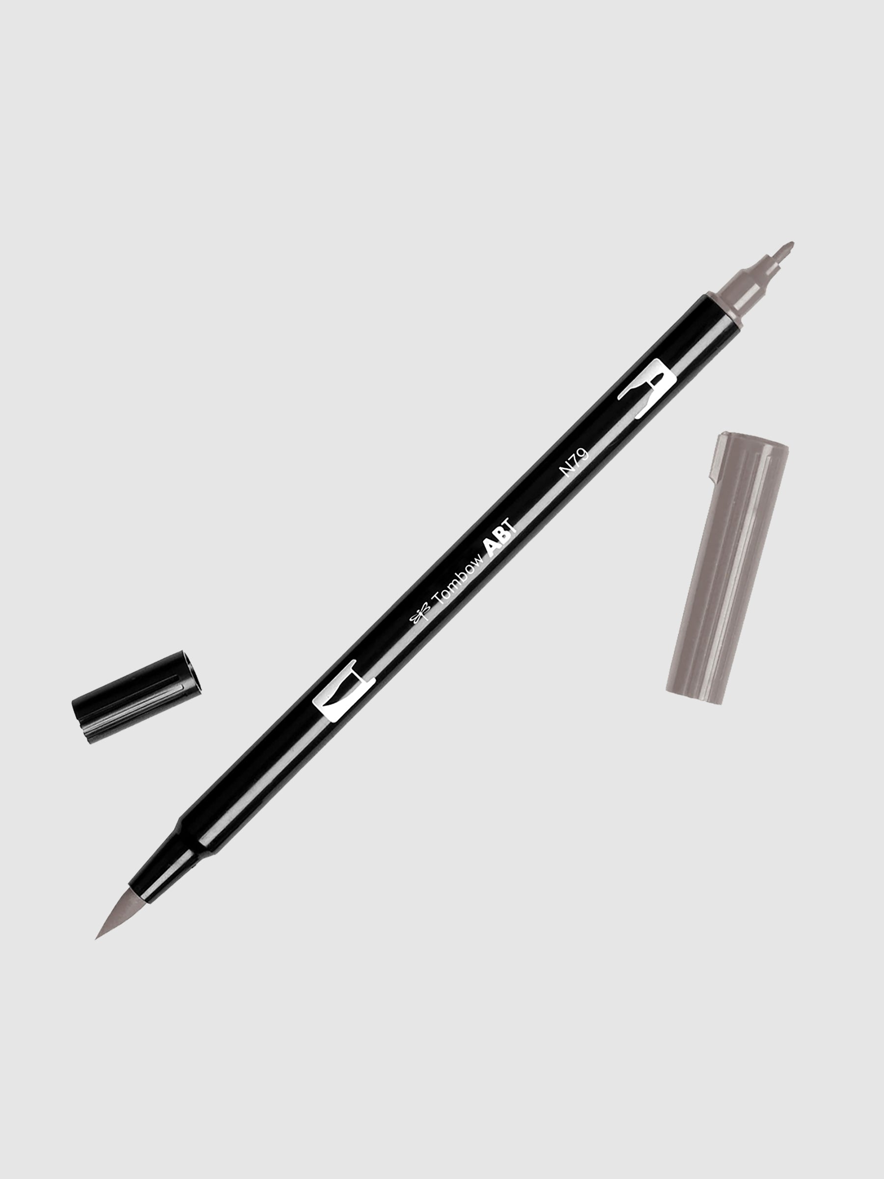 Tombow Dual Brush Art Marker, Warm Gray 2, Cloth & Paper. Art marker turned slightly to the right on a neutral background. It is uncapped on both ends showing the brush tip and fine tip.