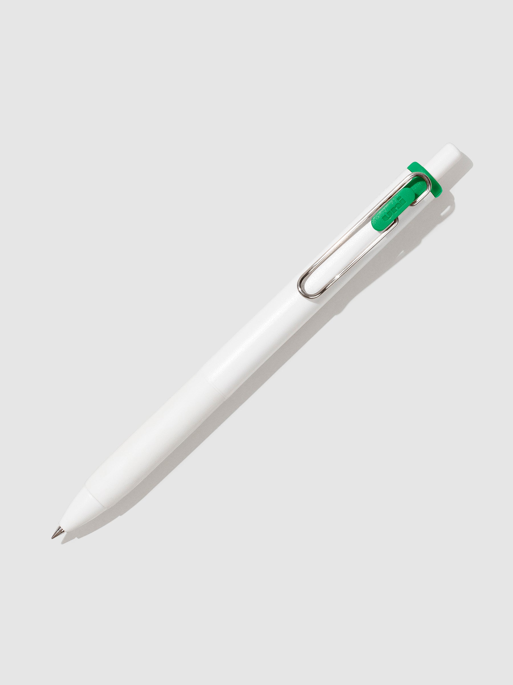 Uni-ball One Gel Pen, Palm Green, Cloth and Paper. Pen tilted slightly to the right on a neutral background.
